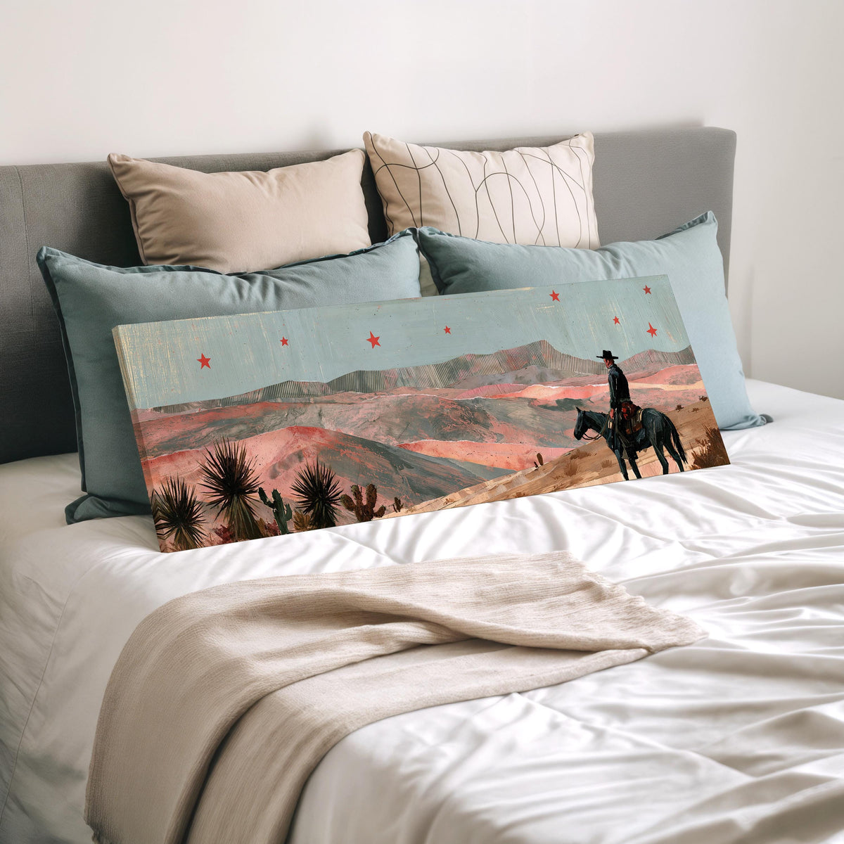 Desert cowboy under red stars wide panoramic canvas print laid on a bed to show its size