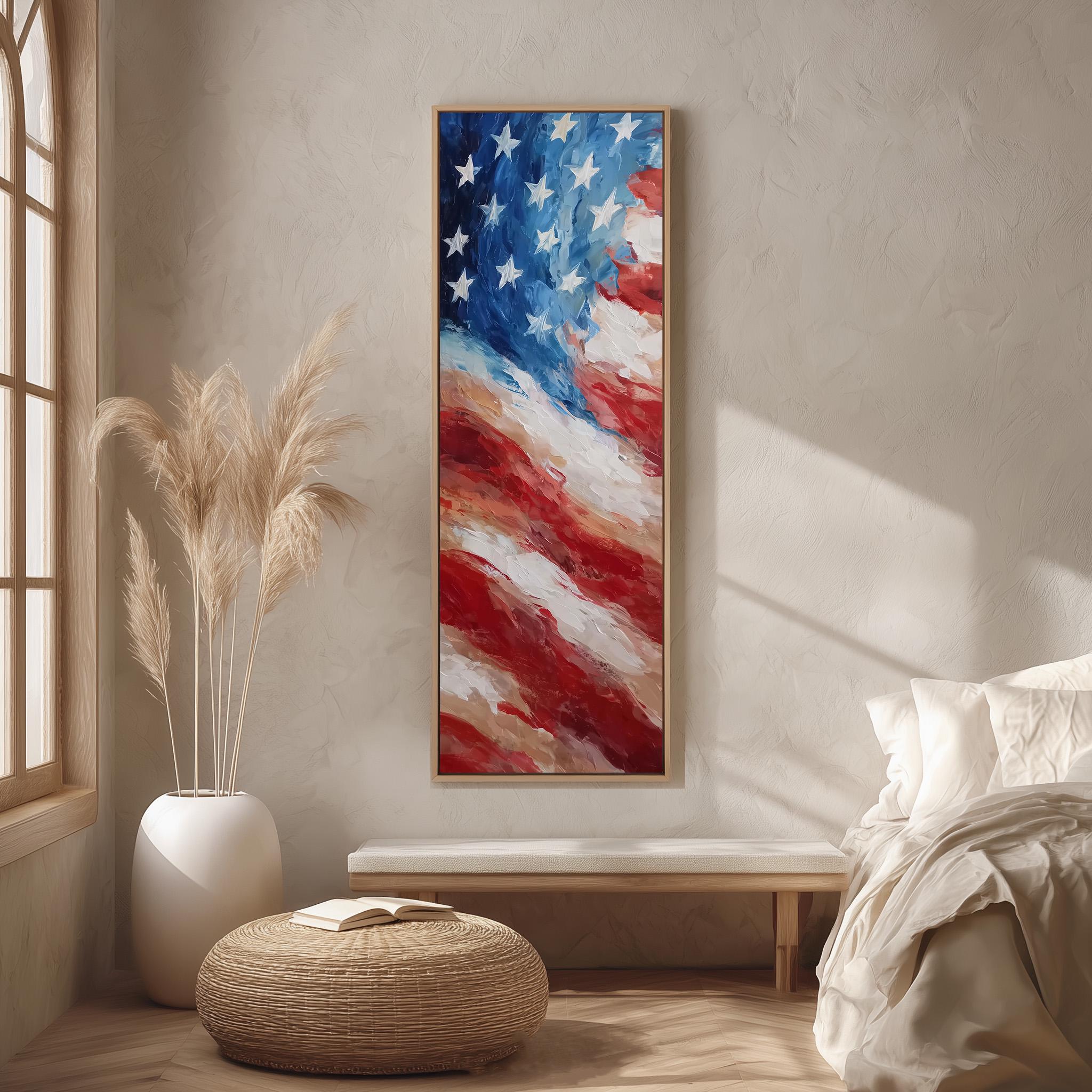 a large American flag painting hanging on a wall, with a white bed and a wicker ottoman in the foreground.