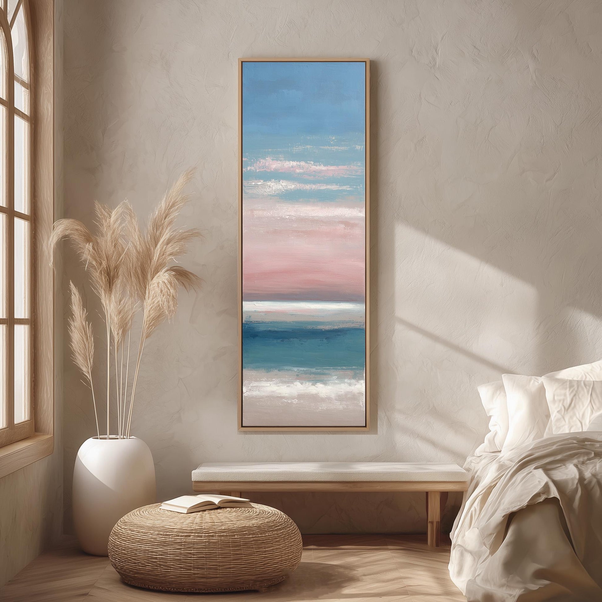 a serene bedroom scene with a large painting of a beach scene hanging on the wall, a white bed with a white pillow, a white vase with tall potted plants, and a woven ottoman in front of the bed.