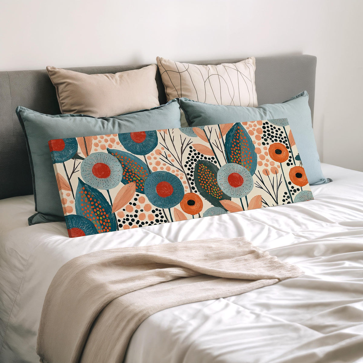 Teal poppies and speckled leaves wide panoramic canvas print laid on a bed to show its size