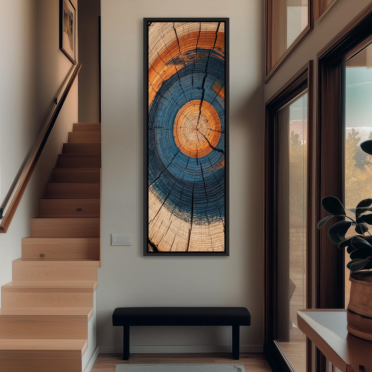 Blue and orange tree ring tall narrow canvas print beside a staircase in an entryway