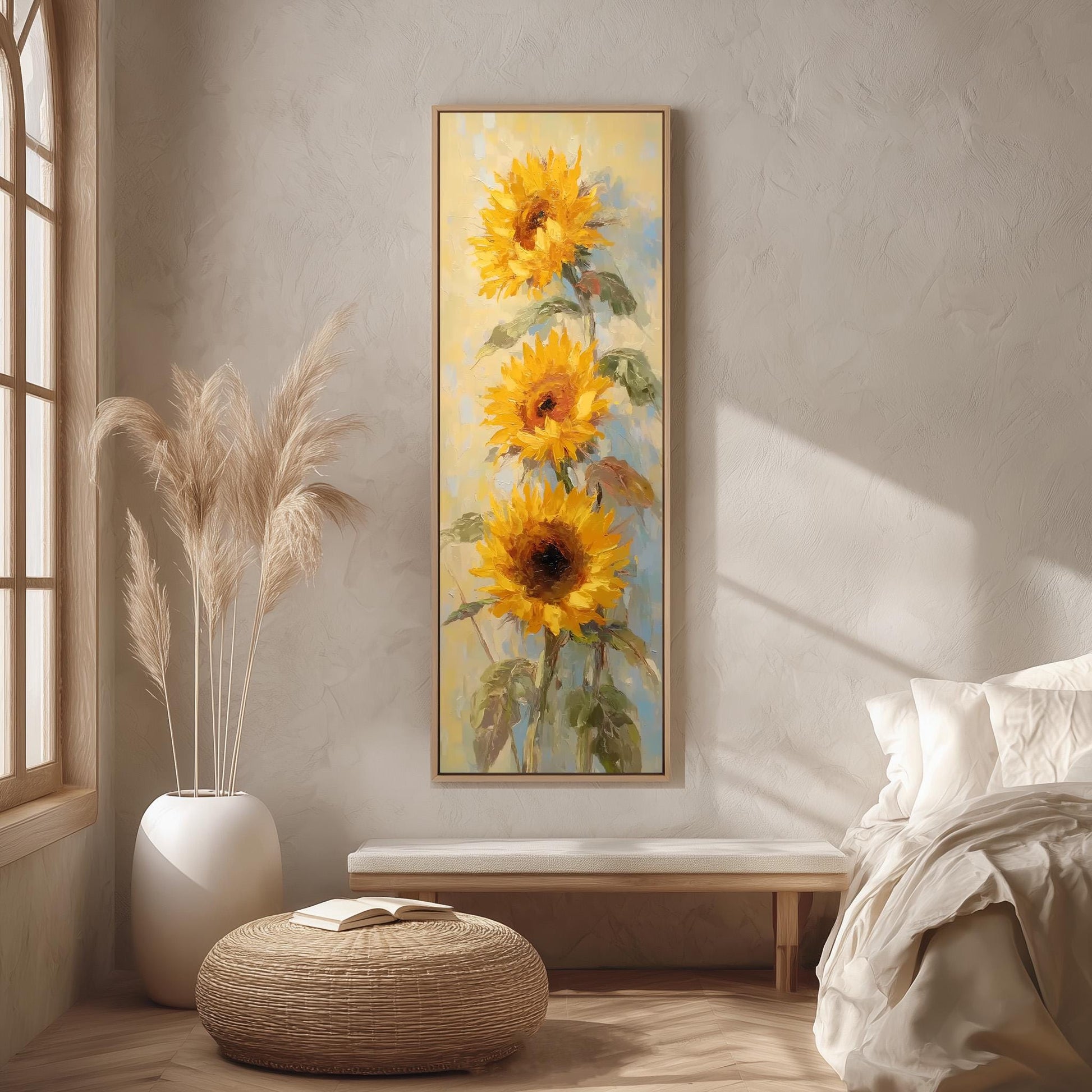 a large painting of three sunflowers hanging on a wall in a room with a bed, a wicker ottoman, and a potted plant.