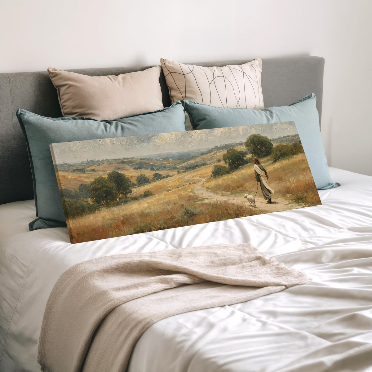 Jesus walking with a sheep on a golden hillside wide panoramic canvas print laid on a bed to show its size
