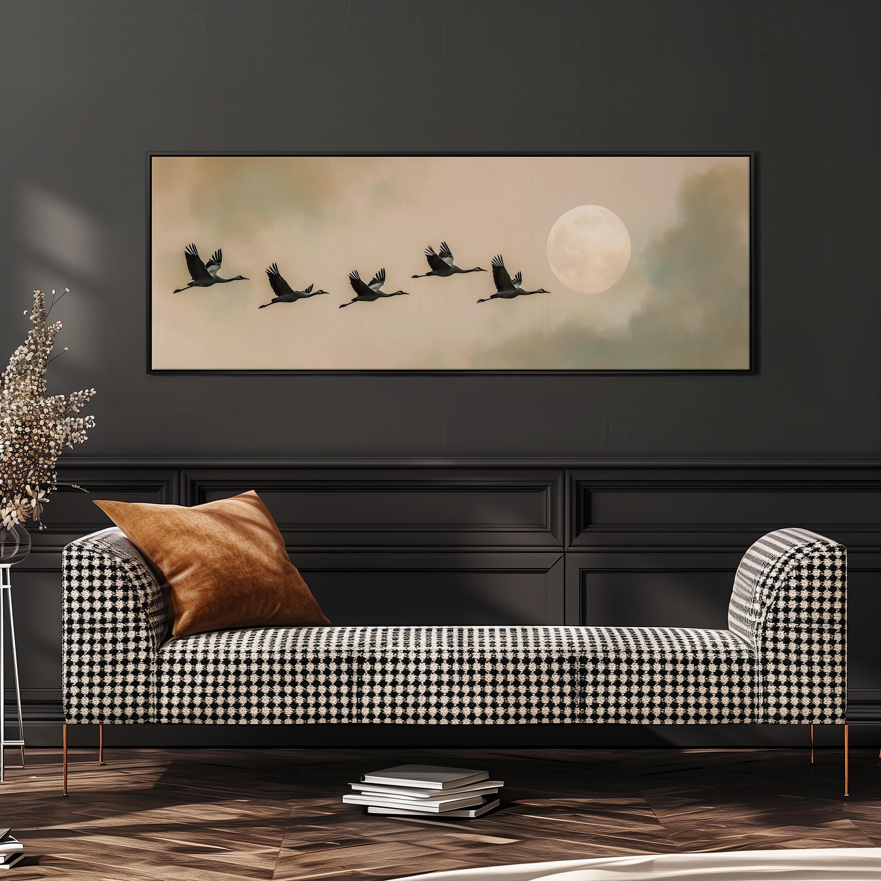 a checkered sofa with a brown throw pillow, and a framed painting of a flock of birds flying across a cloudy sky with a full moon in the background.