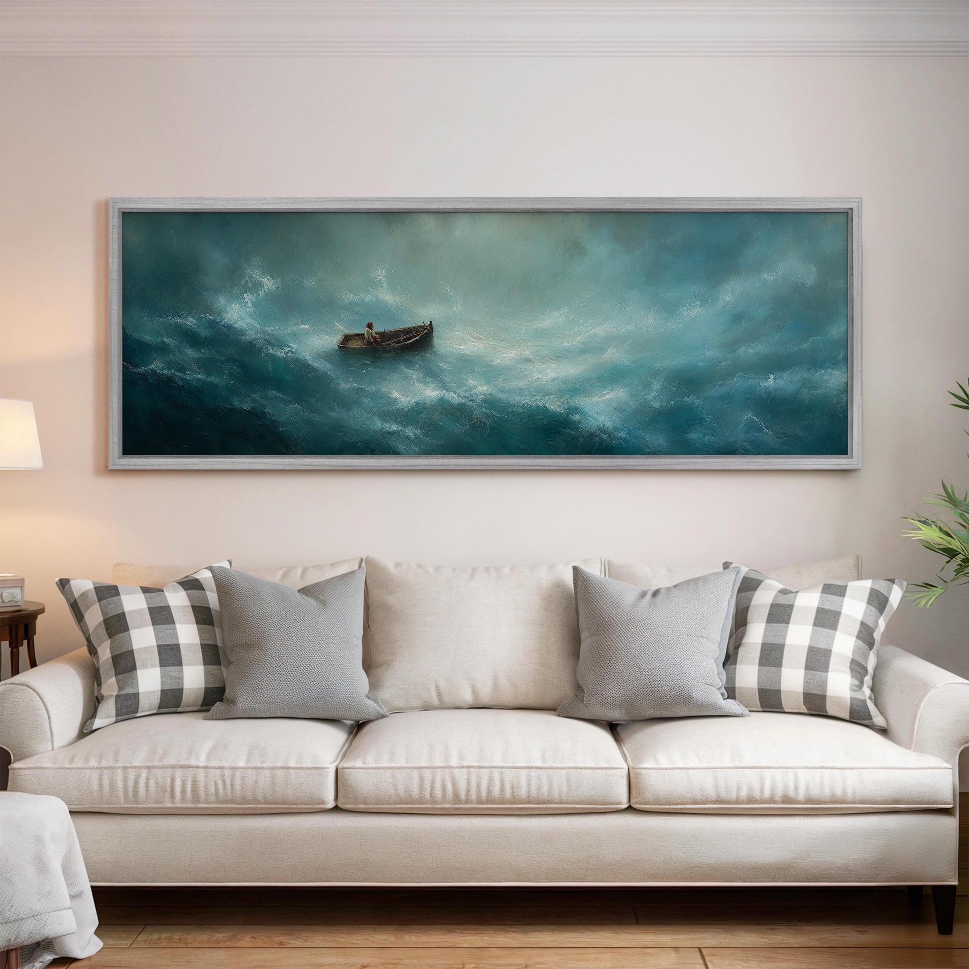 a large painting of a boat on a stormy sea hanging on a wall above a white sofa with gray and white patterned pillows.