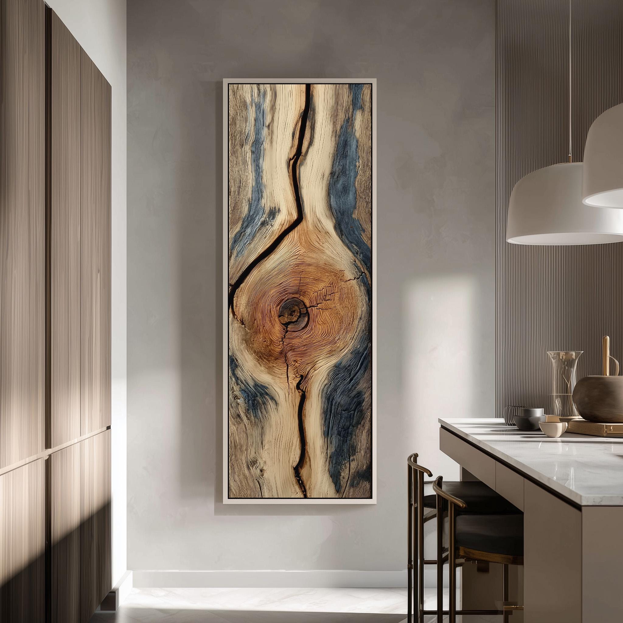 a modern kitchen with a large, abstract painting of a tree trunk hanging on the wall. The painting has a mix of blue, brown, and orange colors, creating a striking contrast against the white wall. The kitchen is equipped with a white countertop and a sink, and there are two chairs placed in front of the counter.