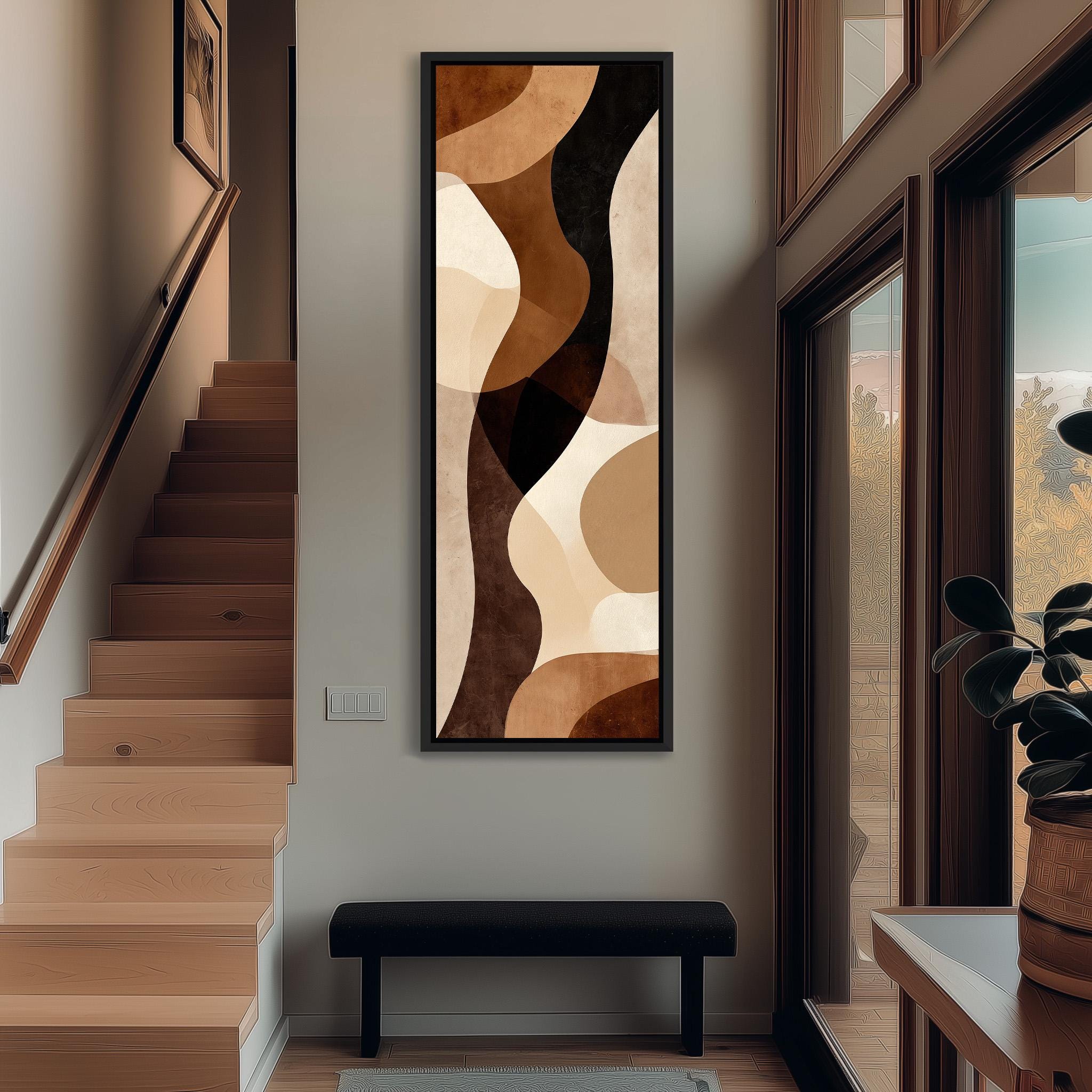 a modern and minimalist interior design with a large abstract painting hanging on the wall above a black bench. The painting has a warm color palette of browns and oranges, creating a cozy and inviting atmosphere. The room also includes a staircase, a potted plant, and a window, contributing to the overall aesthetic and functionality of the space.