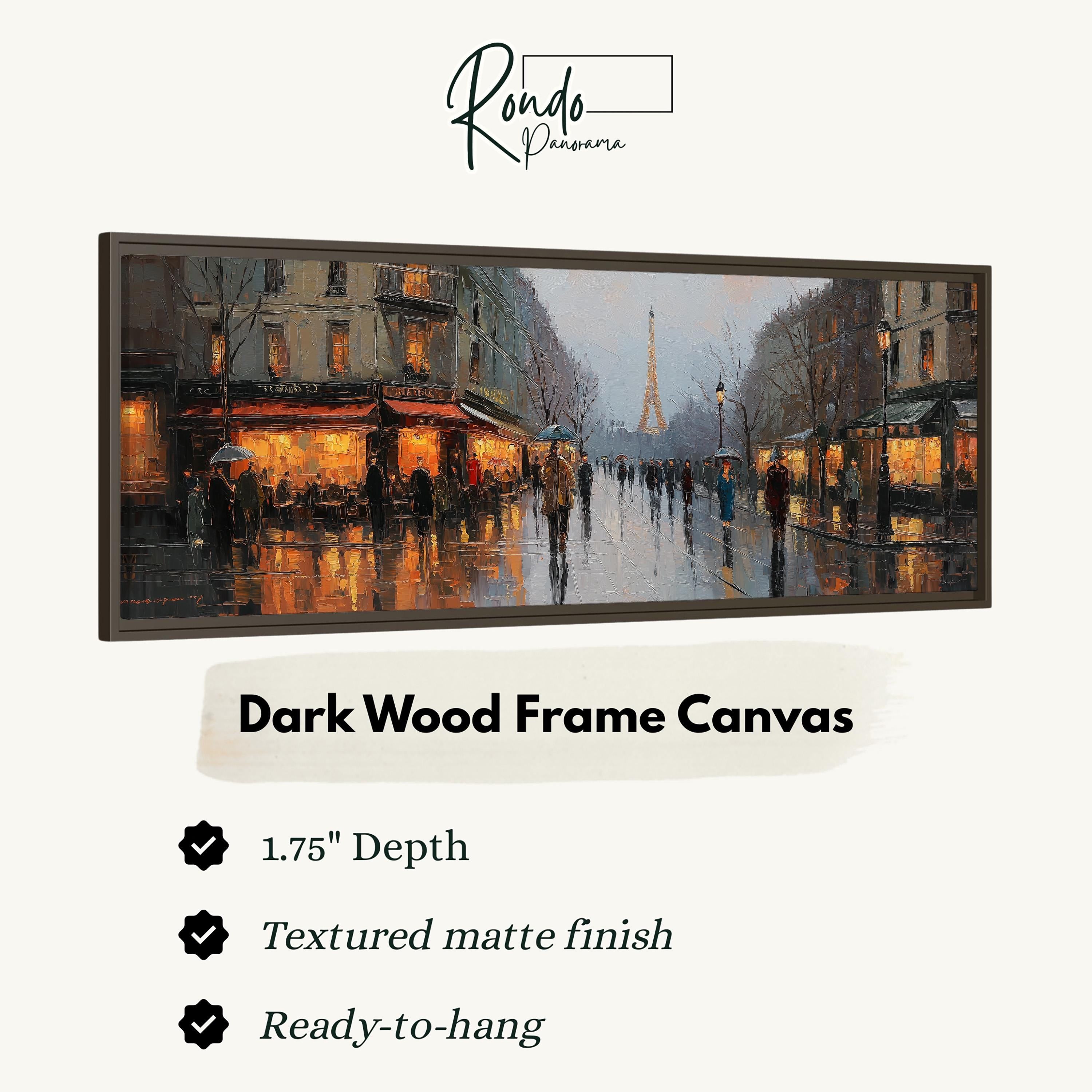 The image is a dark wood frame canvas depicting a rainy city street scene with people walking and buildings illuminated by warm lighting.