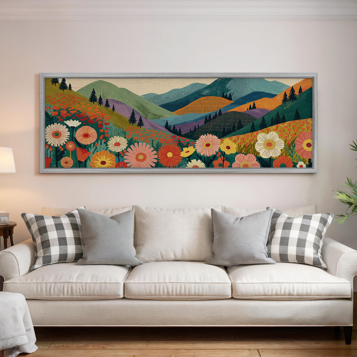 Wildflower valley below patterned mountains panoramic canvas print above a white sofa in a bright living room