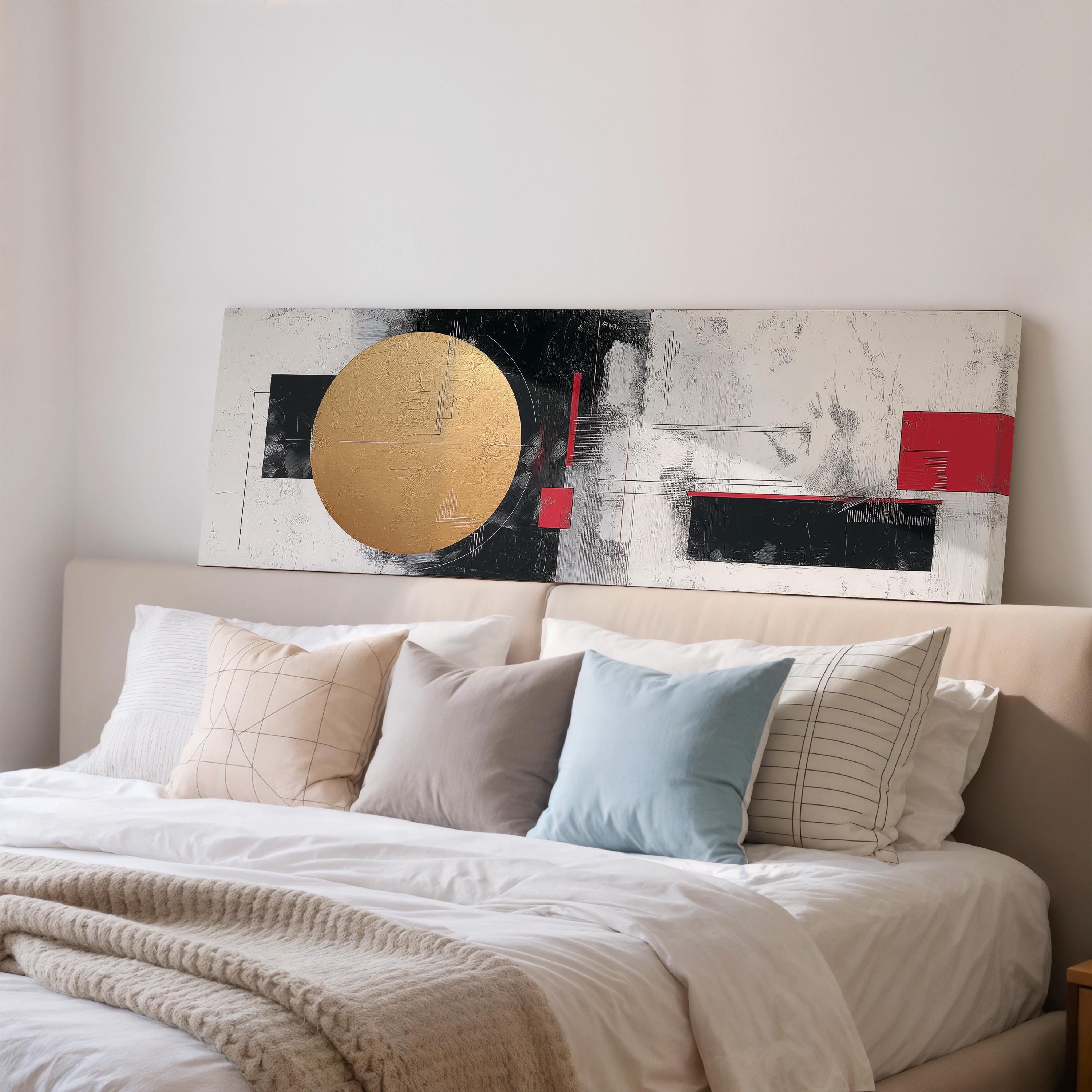 a large abstract painting hanging above a bed with white sheets and pillows.