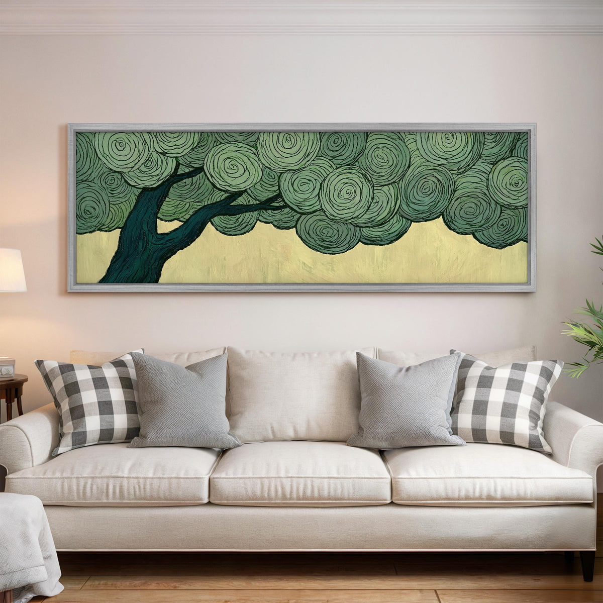 Tree with a swirling green canopy panoramic canvas print above a white sofa in a bright living room