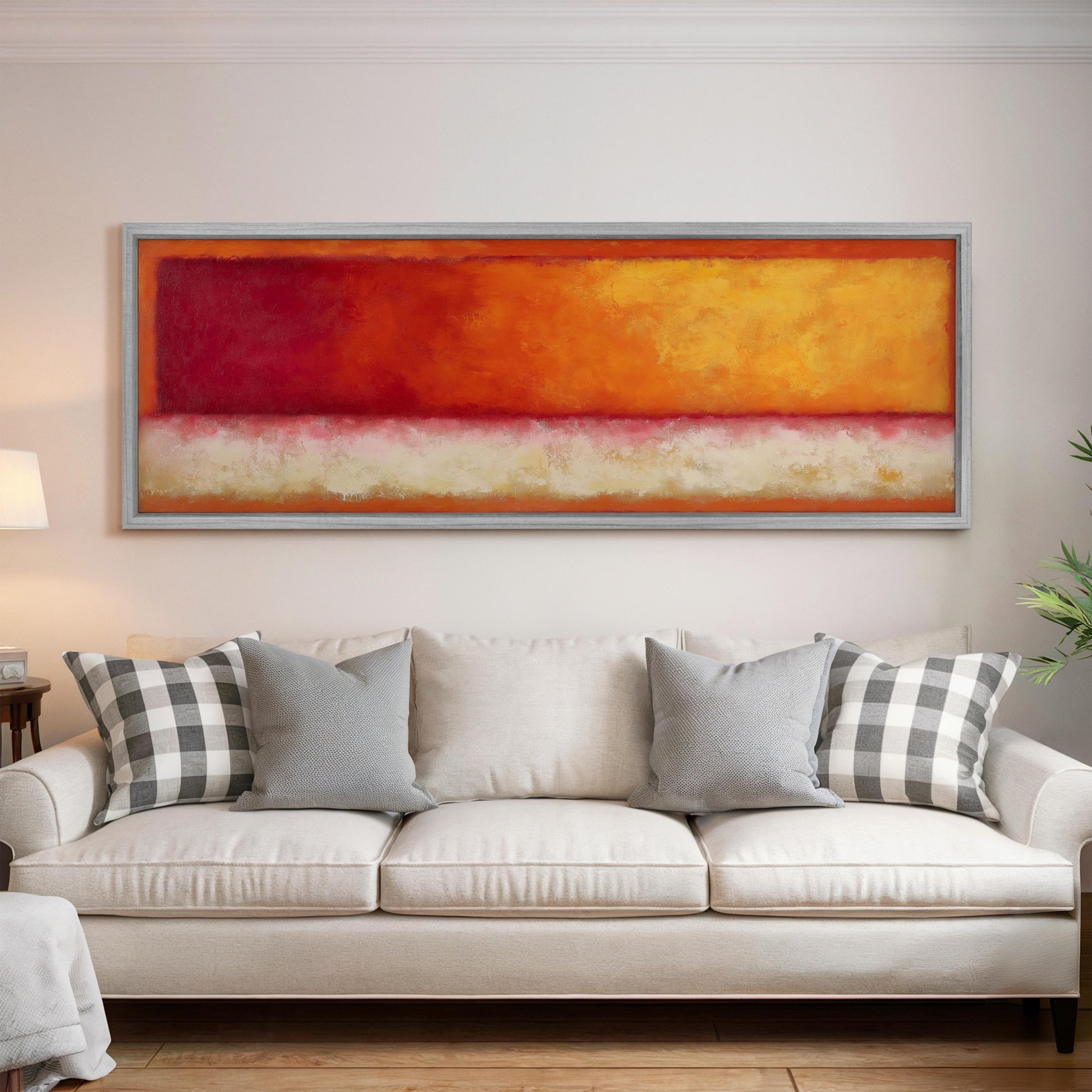a large, colorful abstract painting hanging on a white wall above a white couch with gray and white patterned pillows.