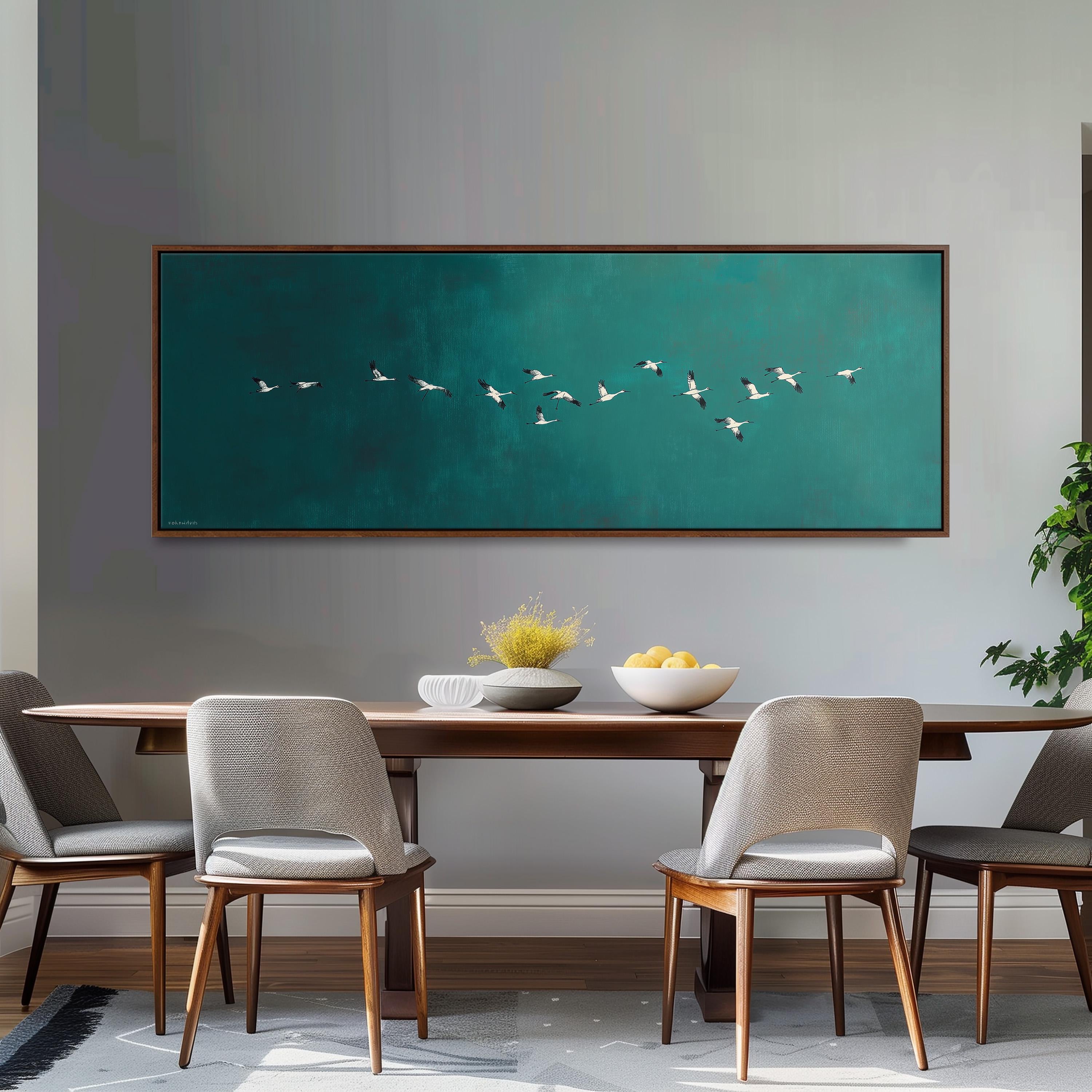a dining room with a wooden table and four chairs, a large framed painting of a flock of birds on the wall above the table, and a bowl of fruit on the table.