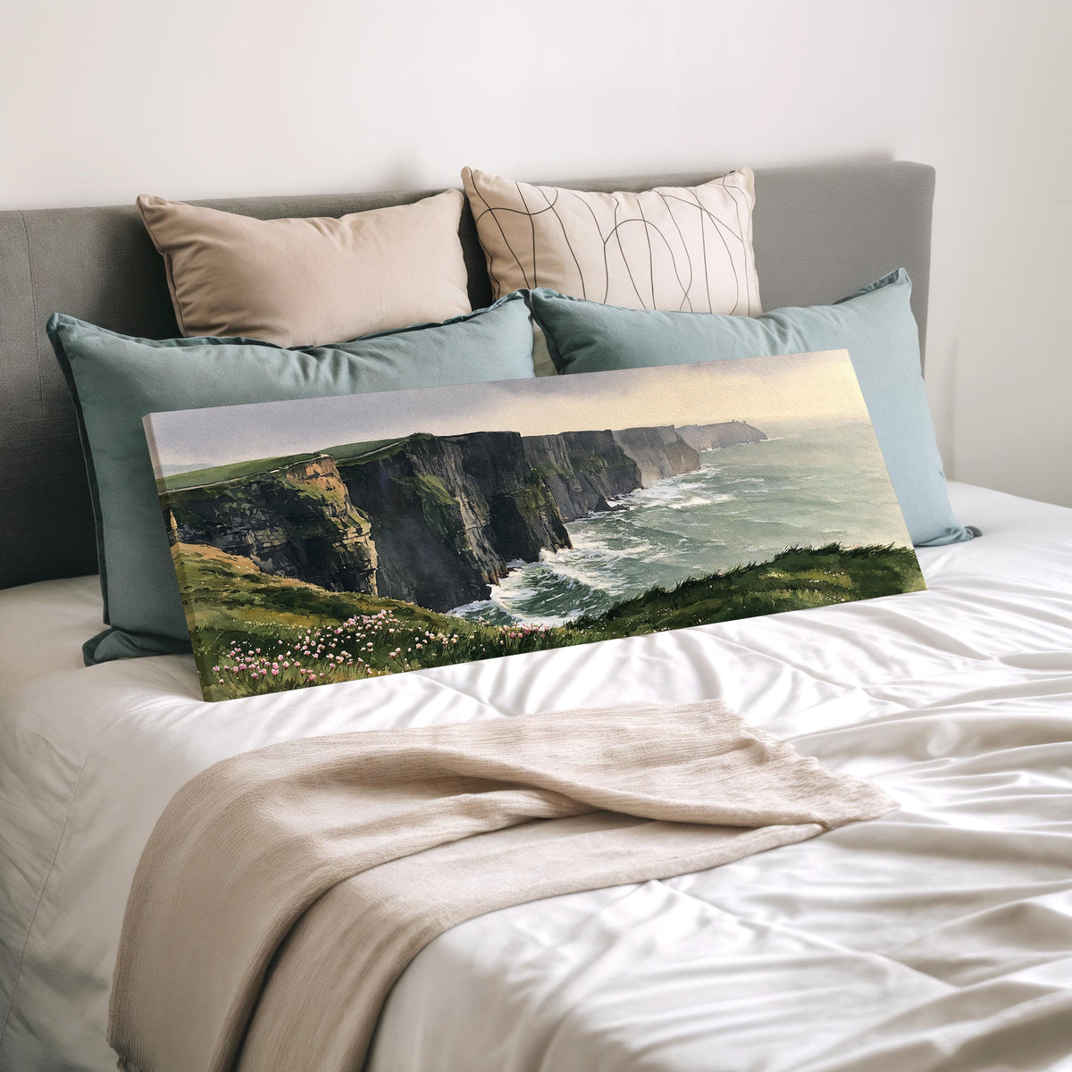 Green sea cliffs with wildflowers wide panoramic canvas print laid on a bed to show its size