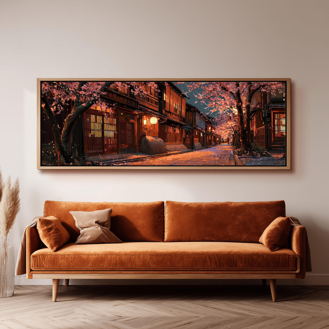 a large, framed painting of a serene street scene with cherry blossoms and traditional Japanese architecture, hanging on a wall above a brown sofa.