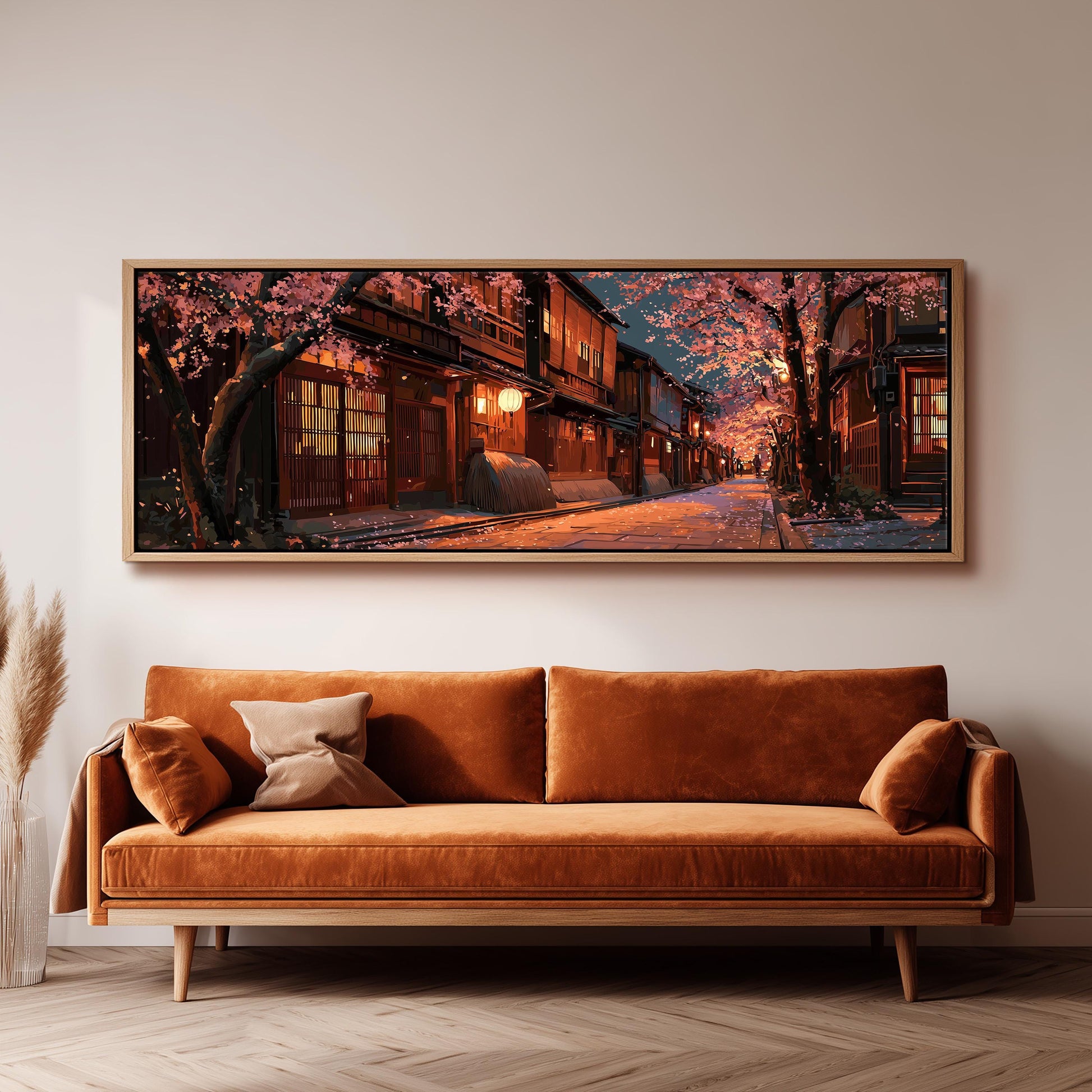 a large, framed painting of a serene street scene with cherry blossoms and traditional Japanese architecture, hanging on a wall above a brown sofa.