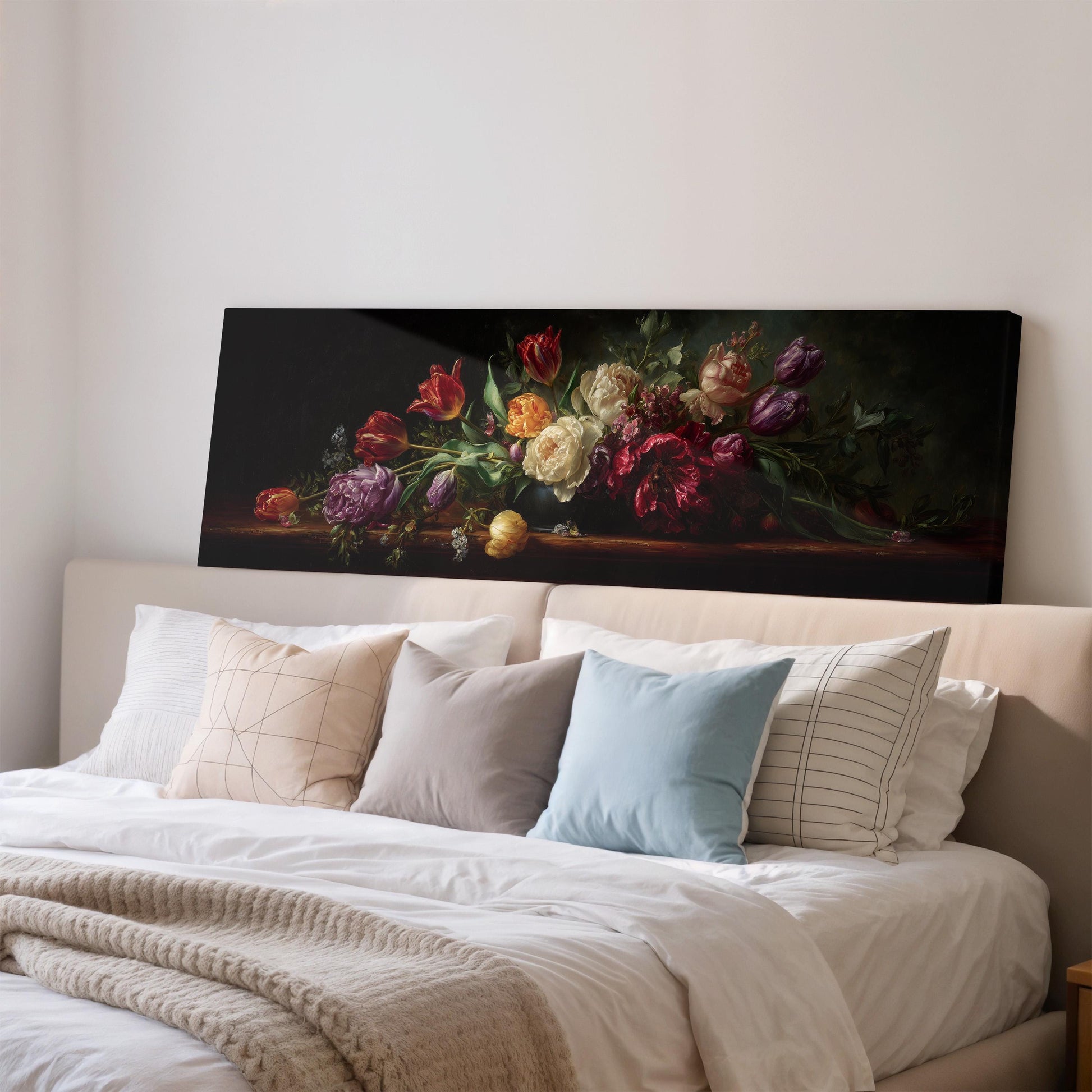 a large painting of a bouquet of flowers displayed on a wall above a bed with white bedding and pillows.