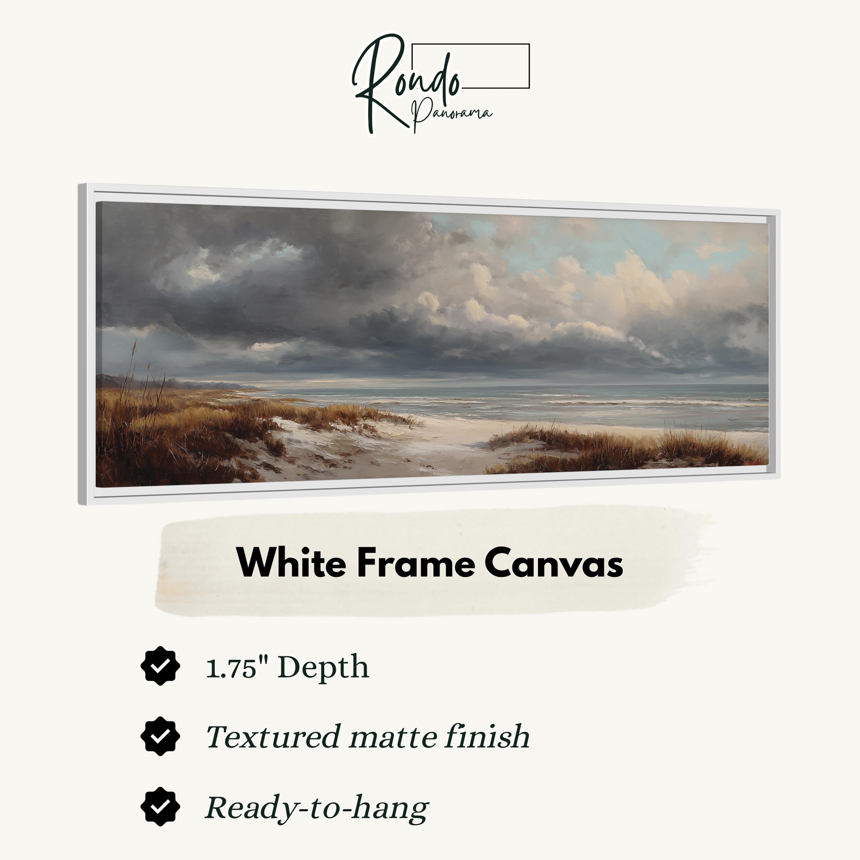 The image is a white frame canvas depicting a serene landscape with a beach, grassy field, and a cloudy sky.