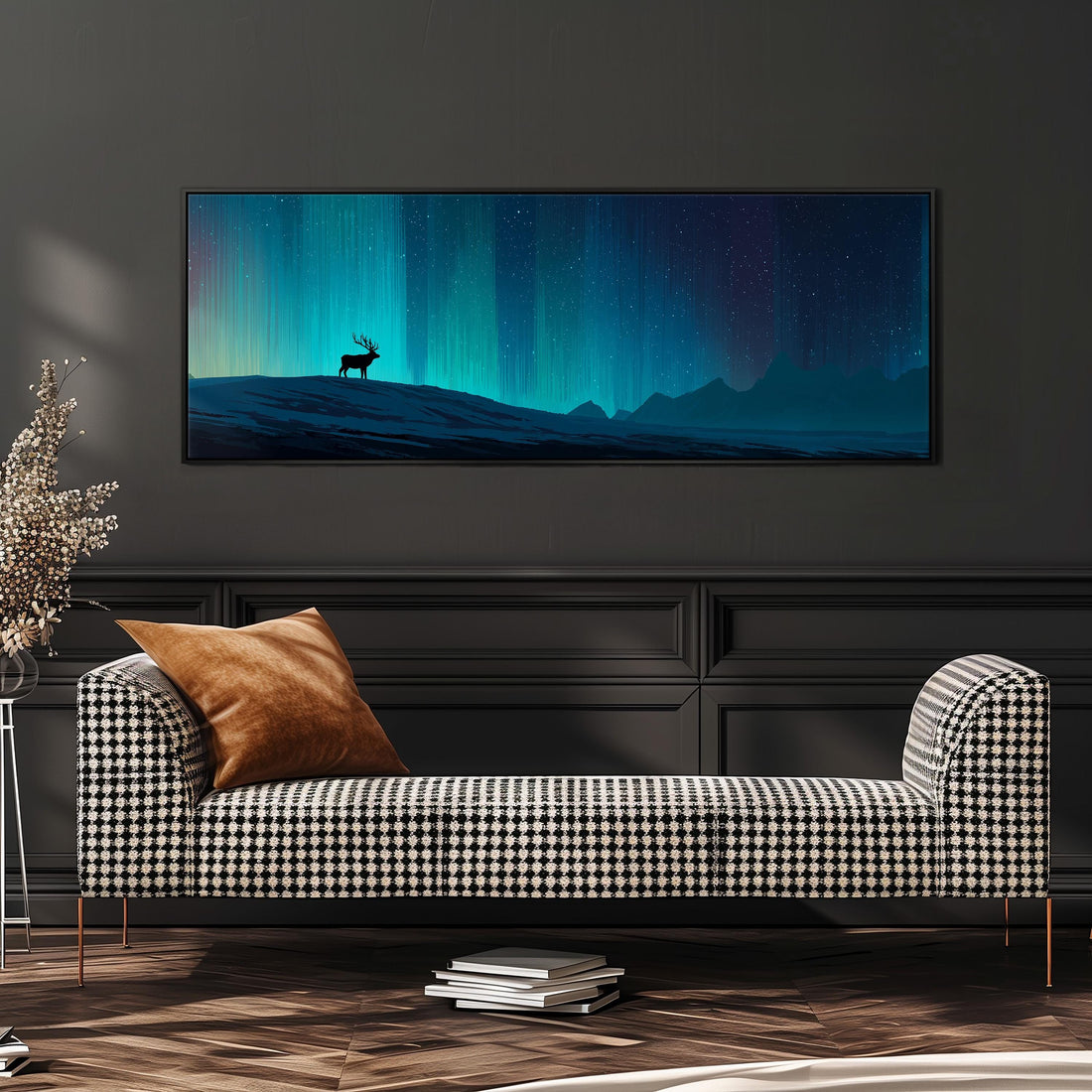 a large, framed painting of a deer standing on a hill against a night sky with a stunning display of the northern lights. The painting is hanging on a wall above a black and white checkered sofa, which is positioned in front of a stack of books.