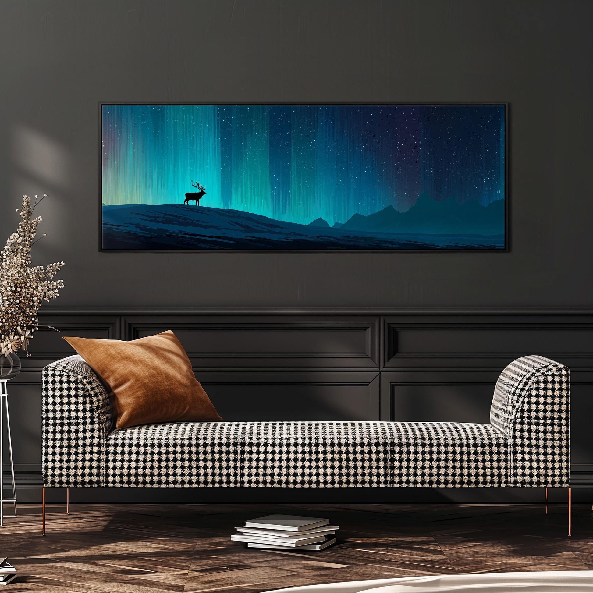 a large, framed painting of a deer standing on a hill against a night sky with a stunning display of the northern lights. The painting is hanging on a wall above a black and white checkered sofa, which is positioned in front of a stack of books.
