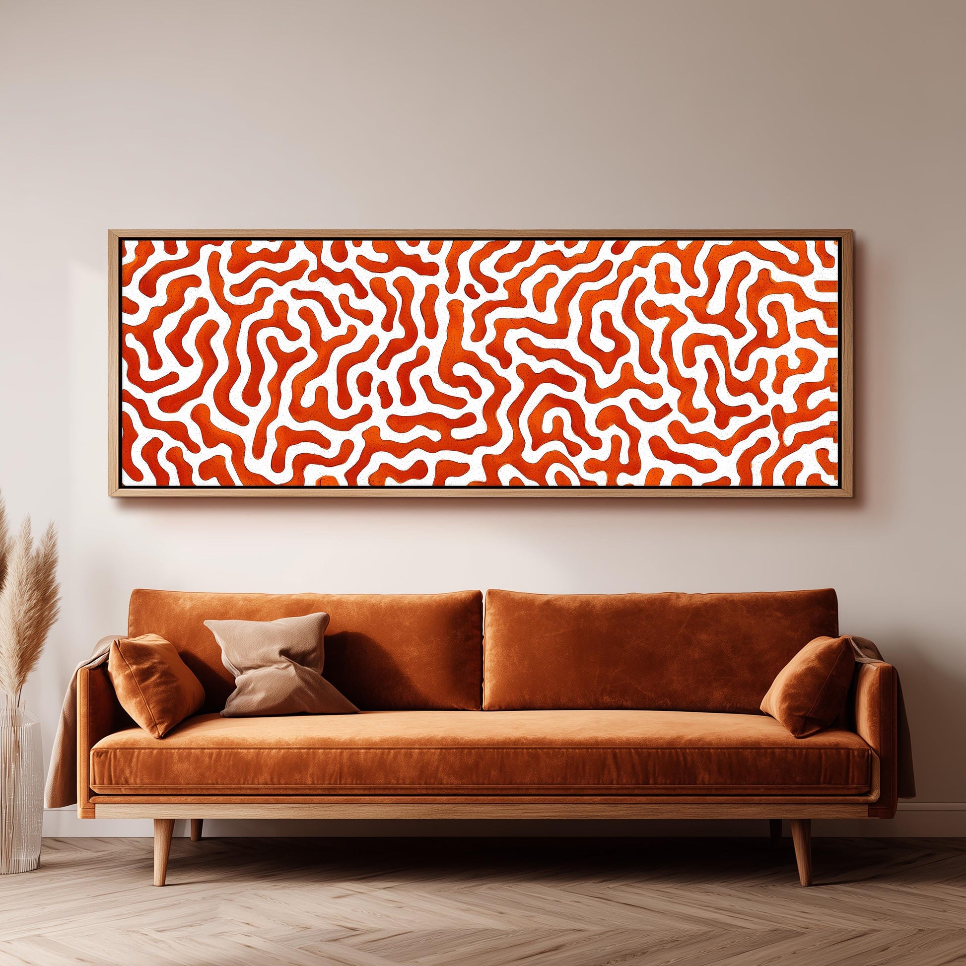 a large, abstract painting hanging on a wall above a brown sofa with two pillows.