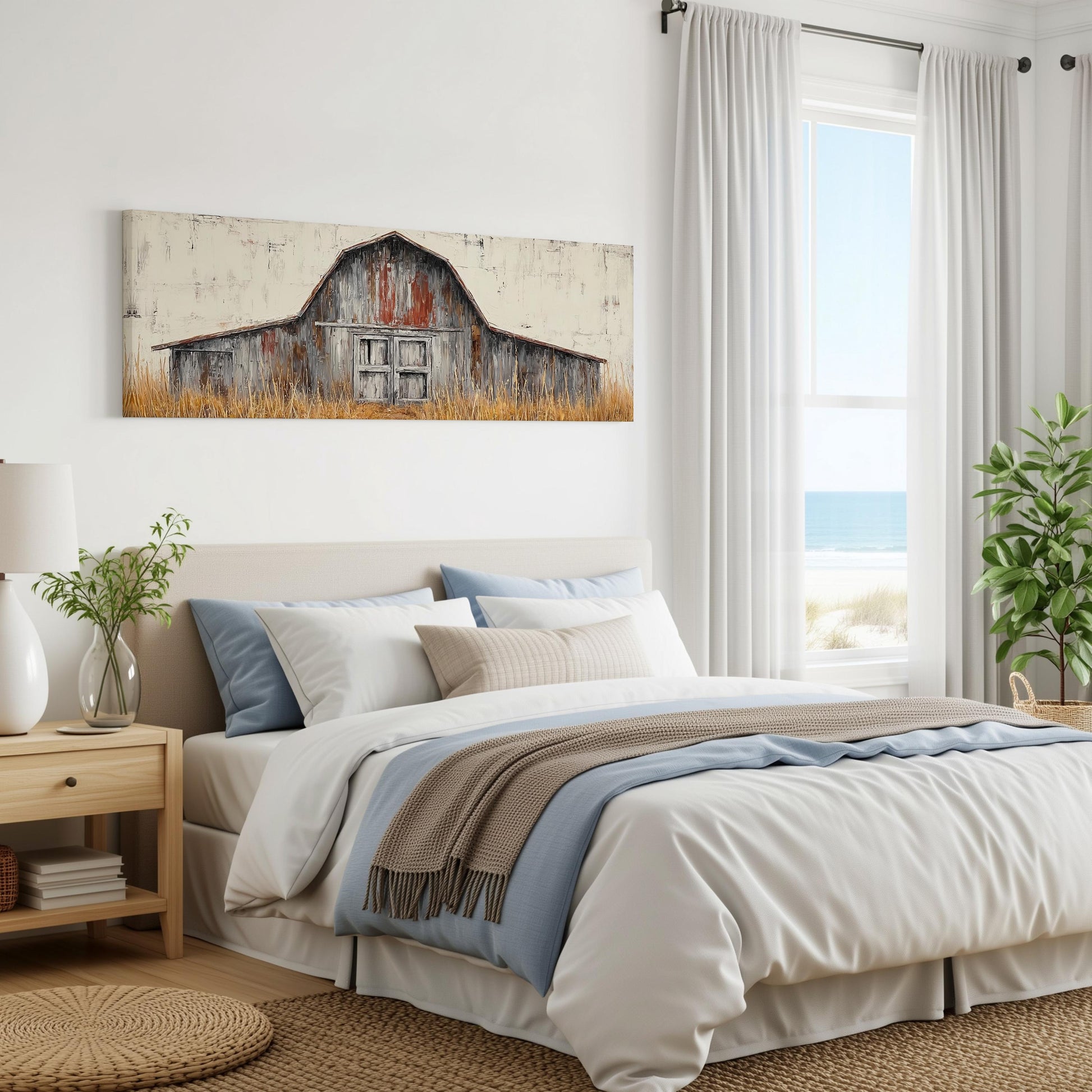 a bedroom with a large bed, a wooden nightstand, and a painting of a barn on the wall. The room has white walls and a window overlooking the ocean.