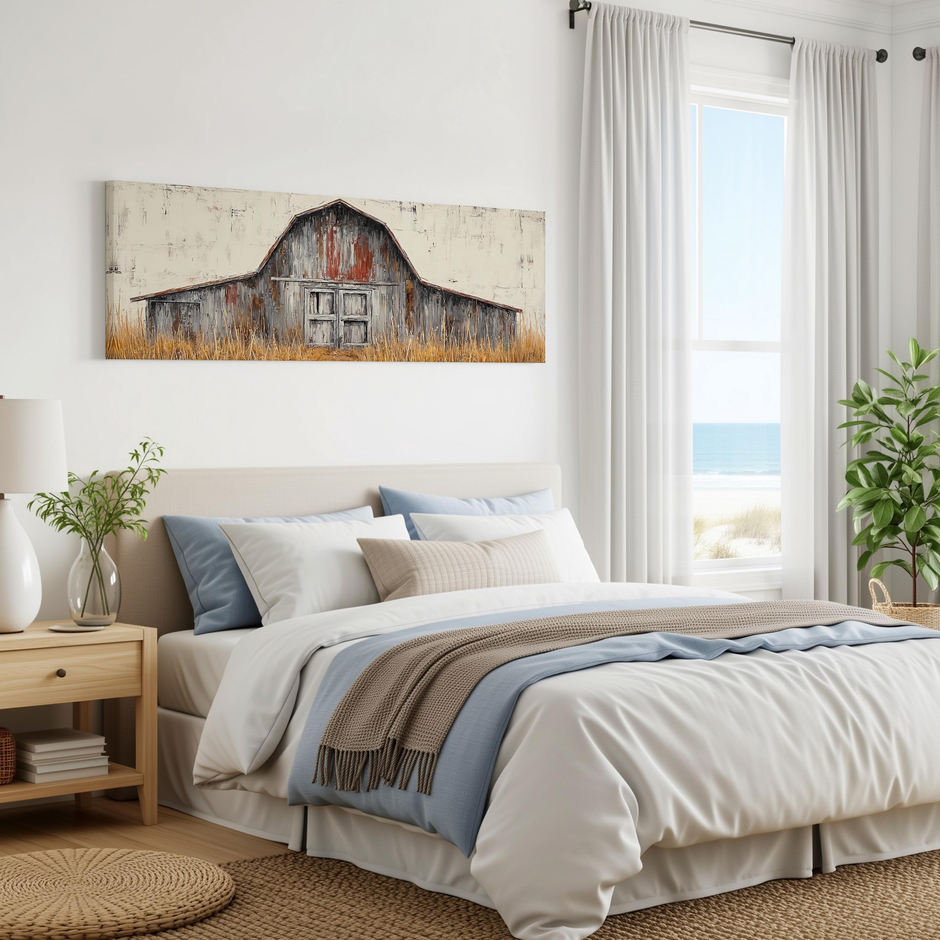 a bedroom with a large bed, a wooden nightstand, and a painting of a barn on the wall. The room has white walls and a window overlooking the ocean.