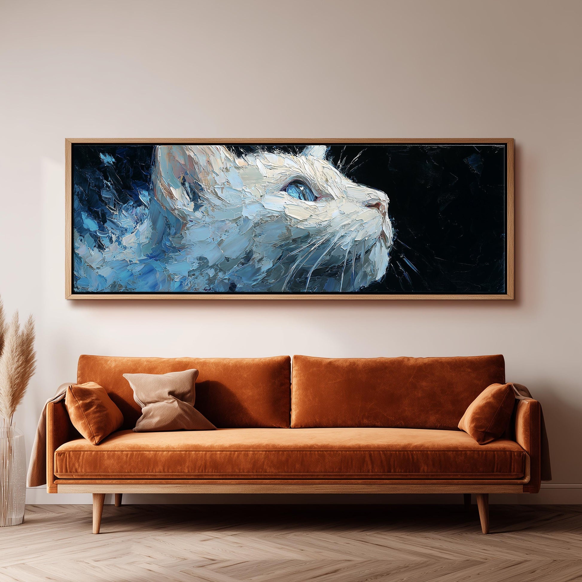 a large, framed painting of a white cat with blue eyes, hanging on a wall above a brown sofa.