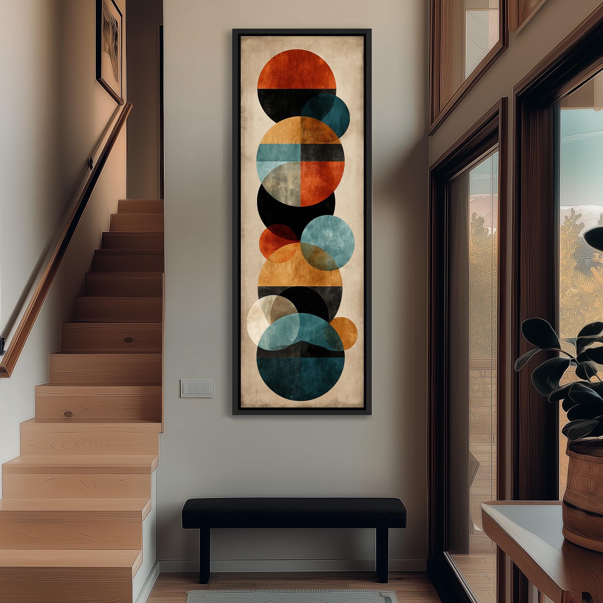 a modern art piece with a geometric design of circles and other shapes, hanging on the wall of a hallway.