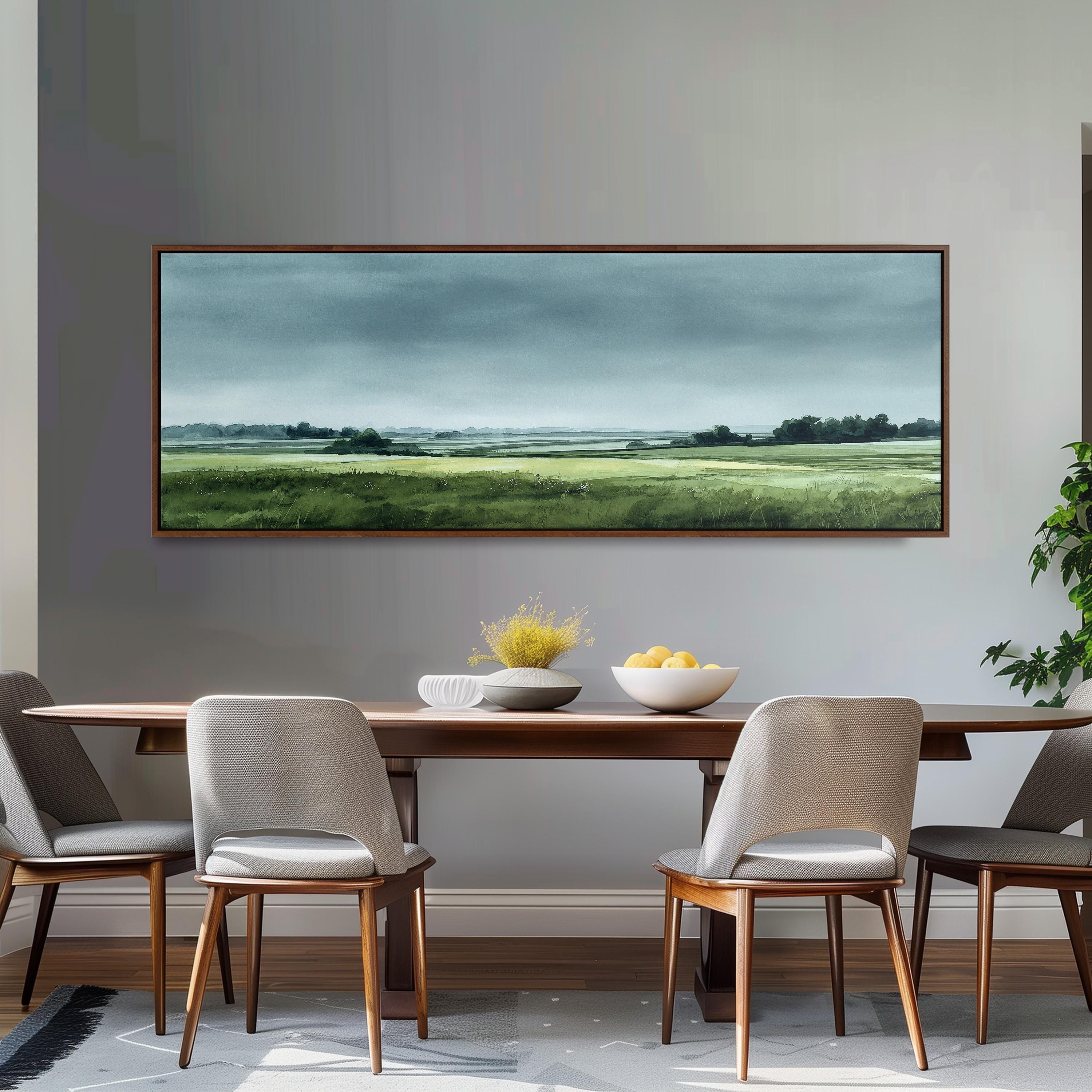 a dining room with a large painting of a countryside landscape hanging on the wall above a wooden dining table with four chairs. The table is set with a bowl of fruit and a vase of flowers, creating a cozy and inviting atmosphere.