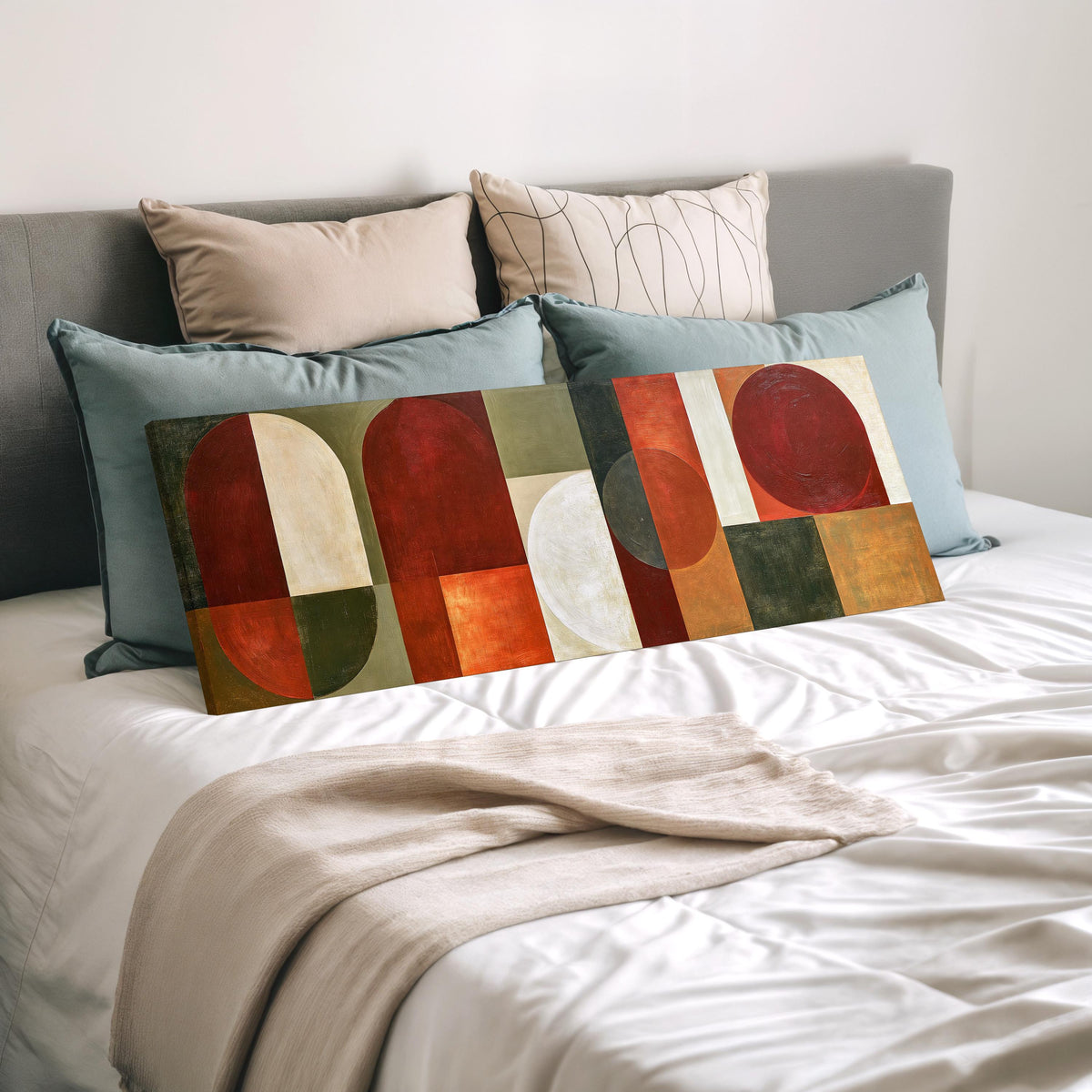 Maroon and olive geometric arches wide panoramic canvas print laid on a bed to show its size