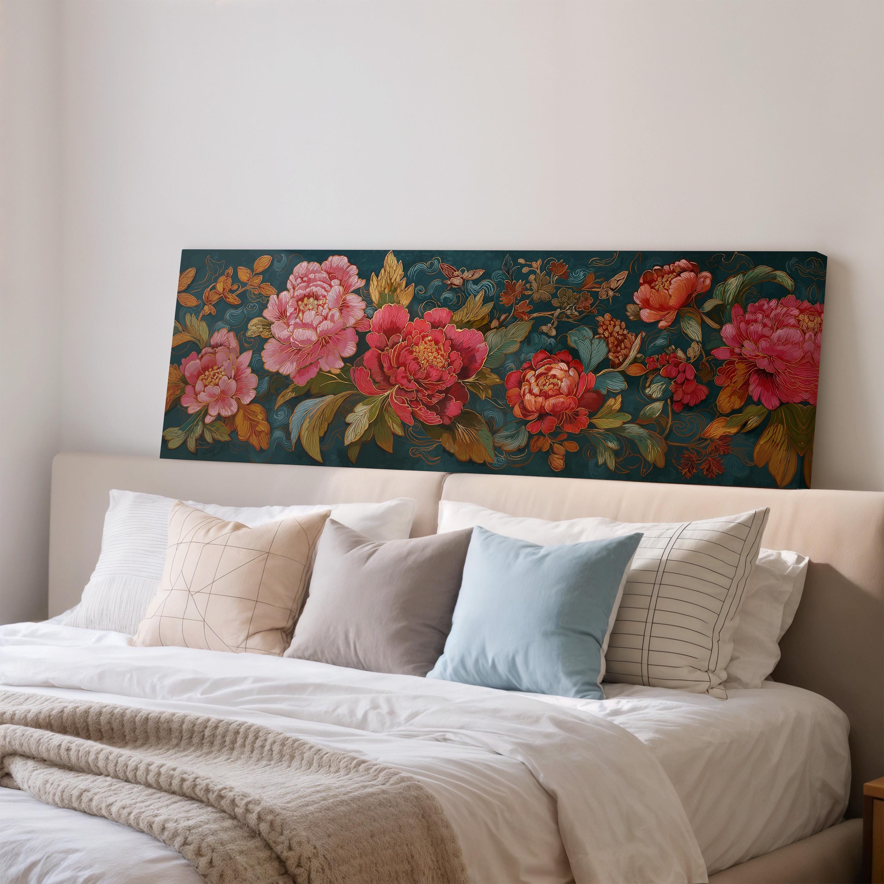 a large floral print on the wall above a bed with white pillows and a gray blanket.