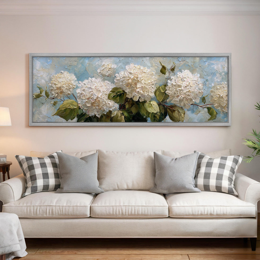 a large painting of white hydrangeas hanging above a bed with white bedding and pillows.