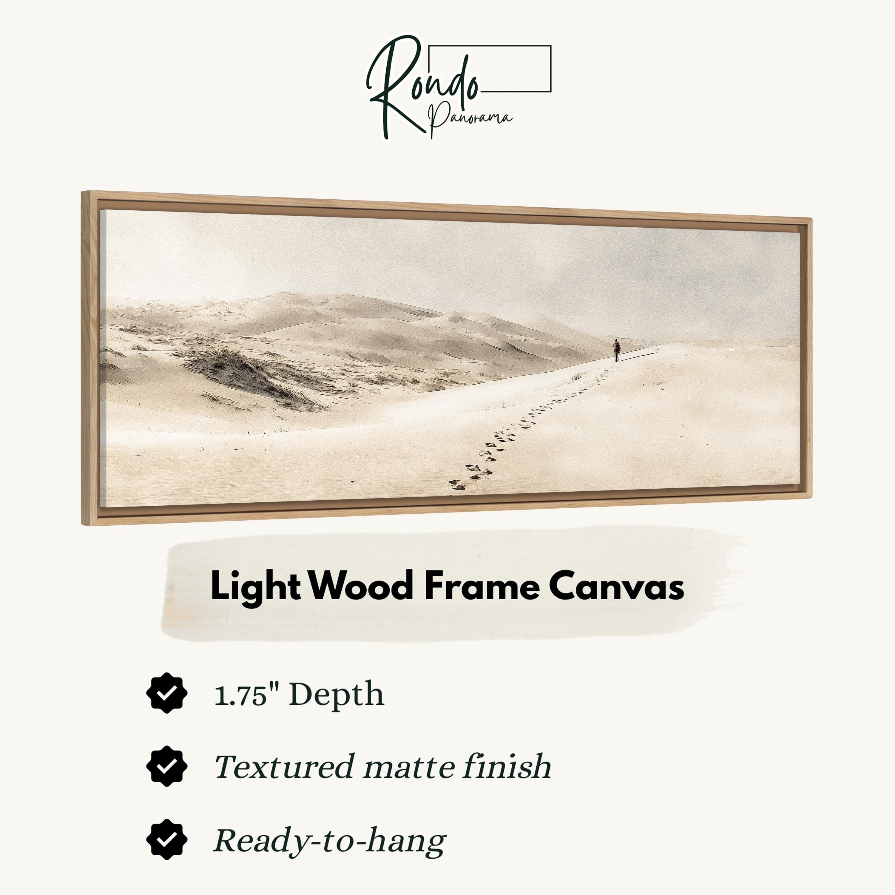 The image is a light wood frame canvas depicting a lone figure walking along a path in a desert landscape.