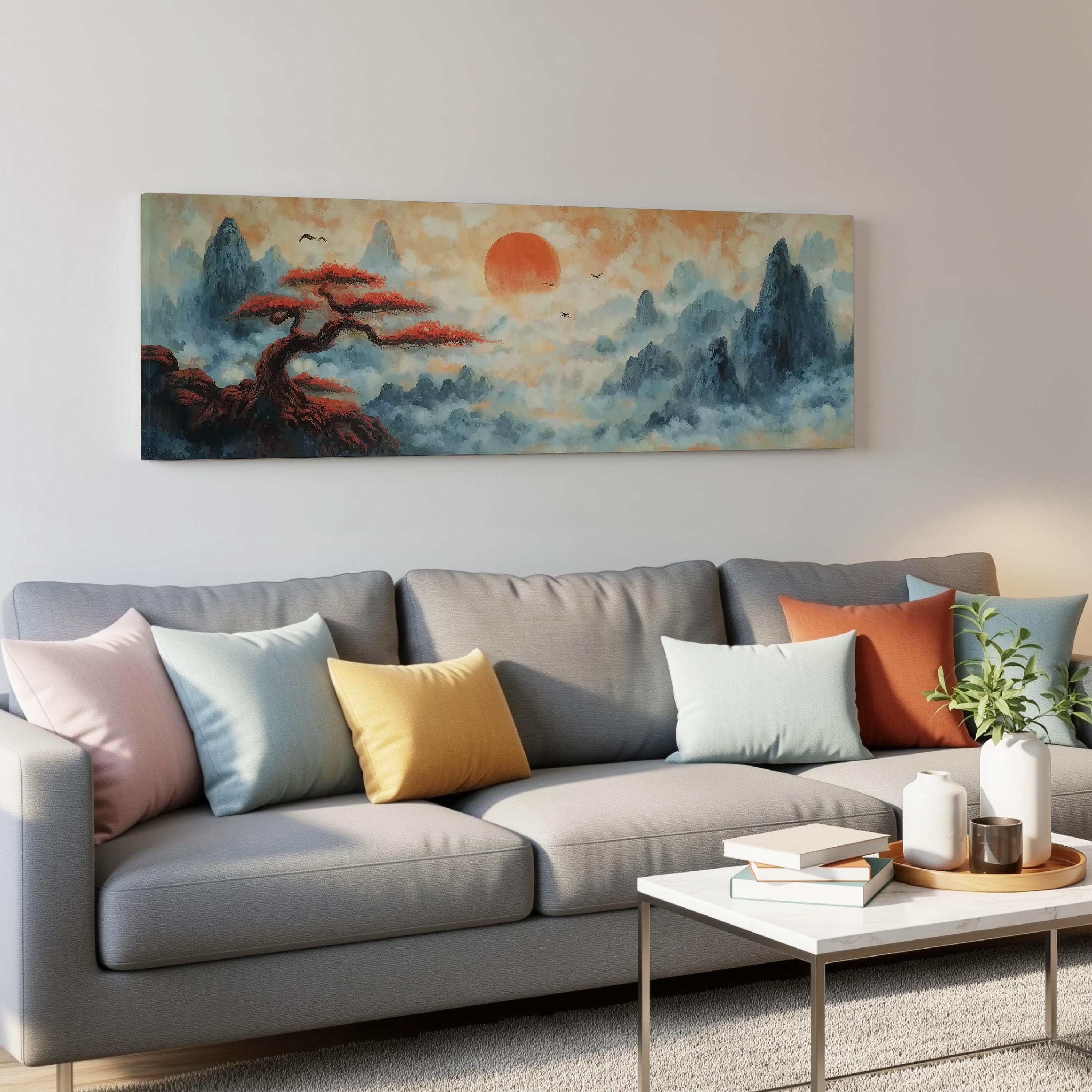 a living room with a gray sofa adorned with colorful throw pillows, a coffee table with books and a plant, and a large landscape painting hanging on the wall above the sofa.