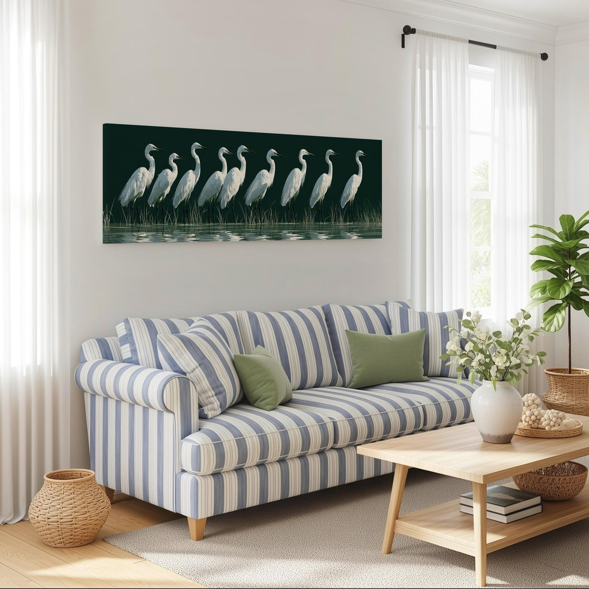 Row of white egrets on deep green long horizontal canvas print above a striped sofa in a coastal living room