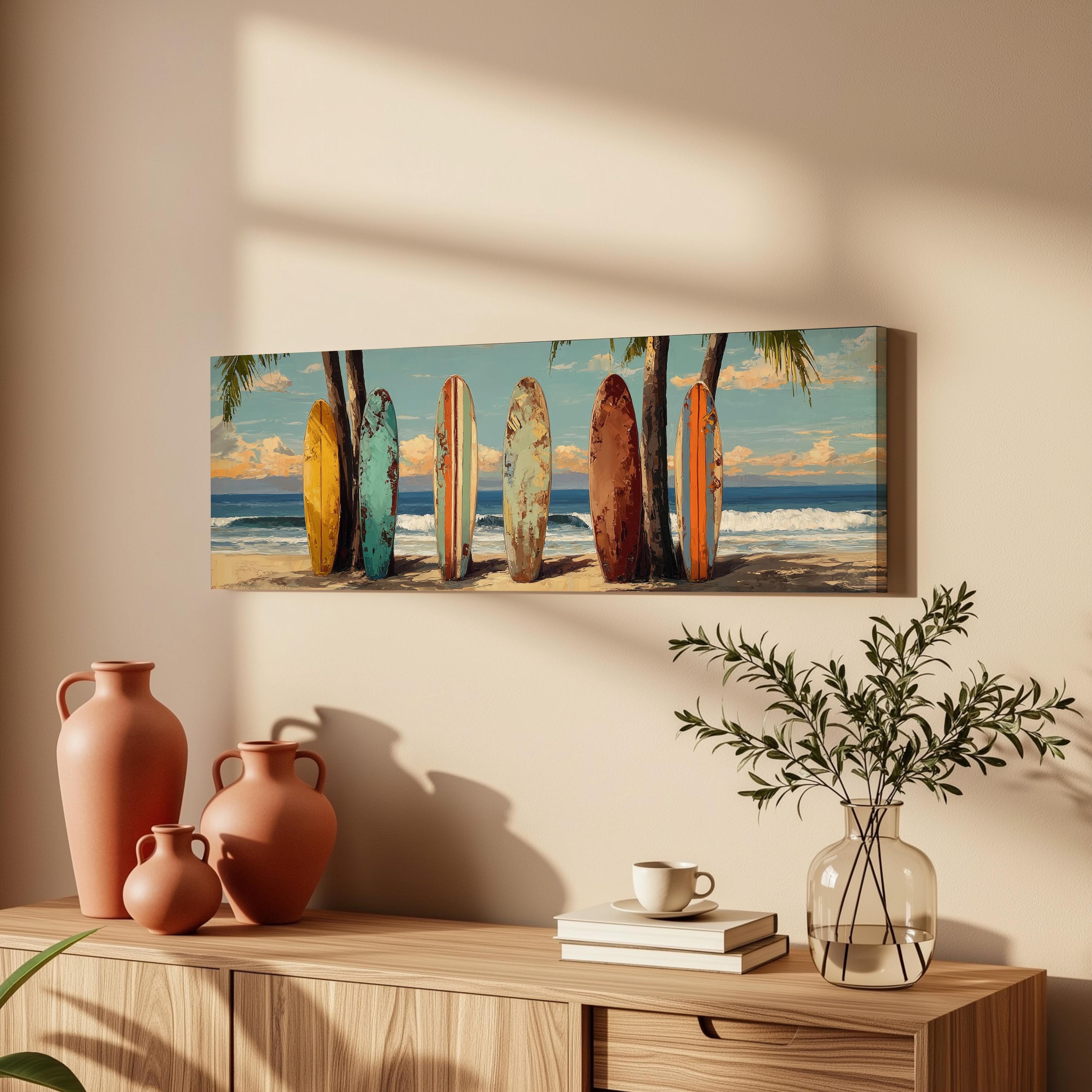 a wall art depicting a beach scene with a row of colorful surfboards leaning against a palm tree. The wall art is hanging above a wooden dresser, which has a vase, a coffee cup, and some books on it.