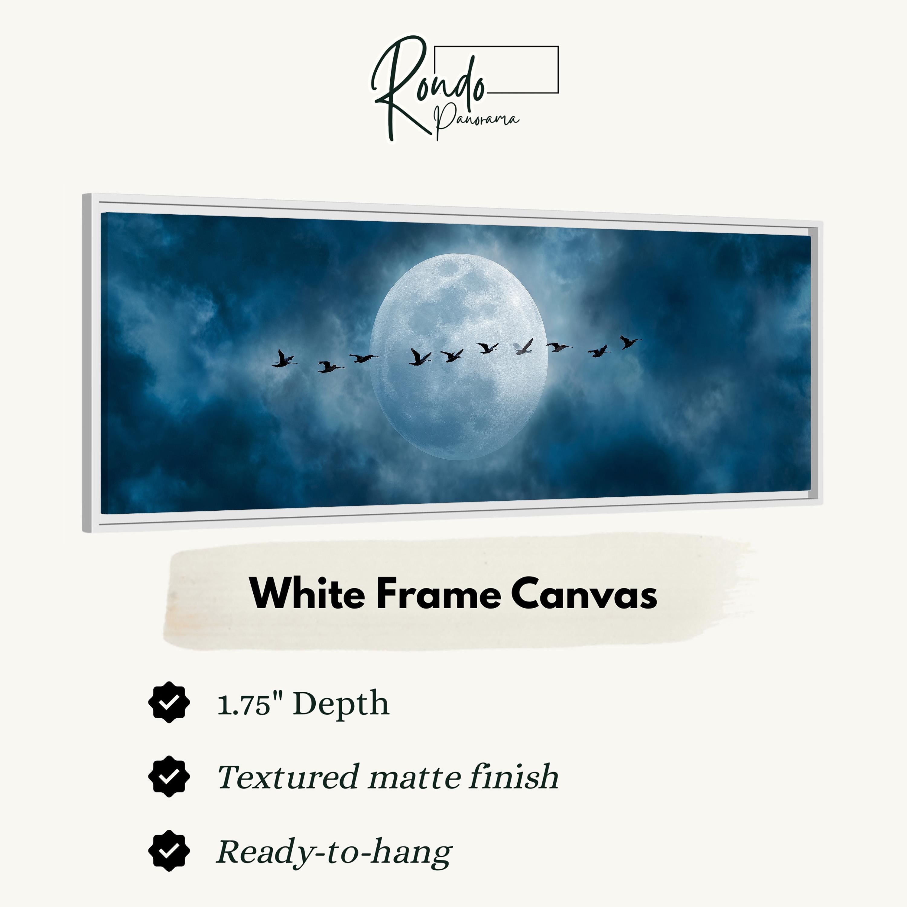 A white frame canvas depicting a flock of birds flying in formation against a backdrop of a full moon and a cloudy sky.