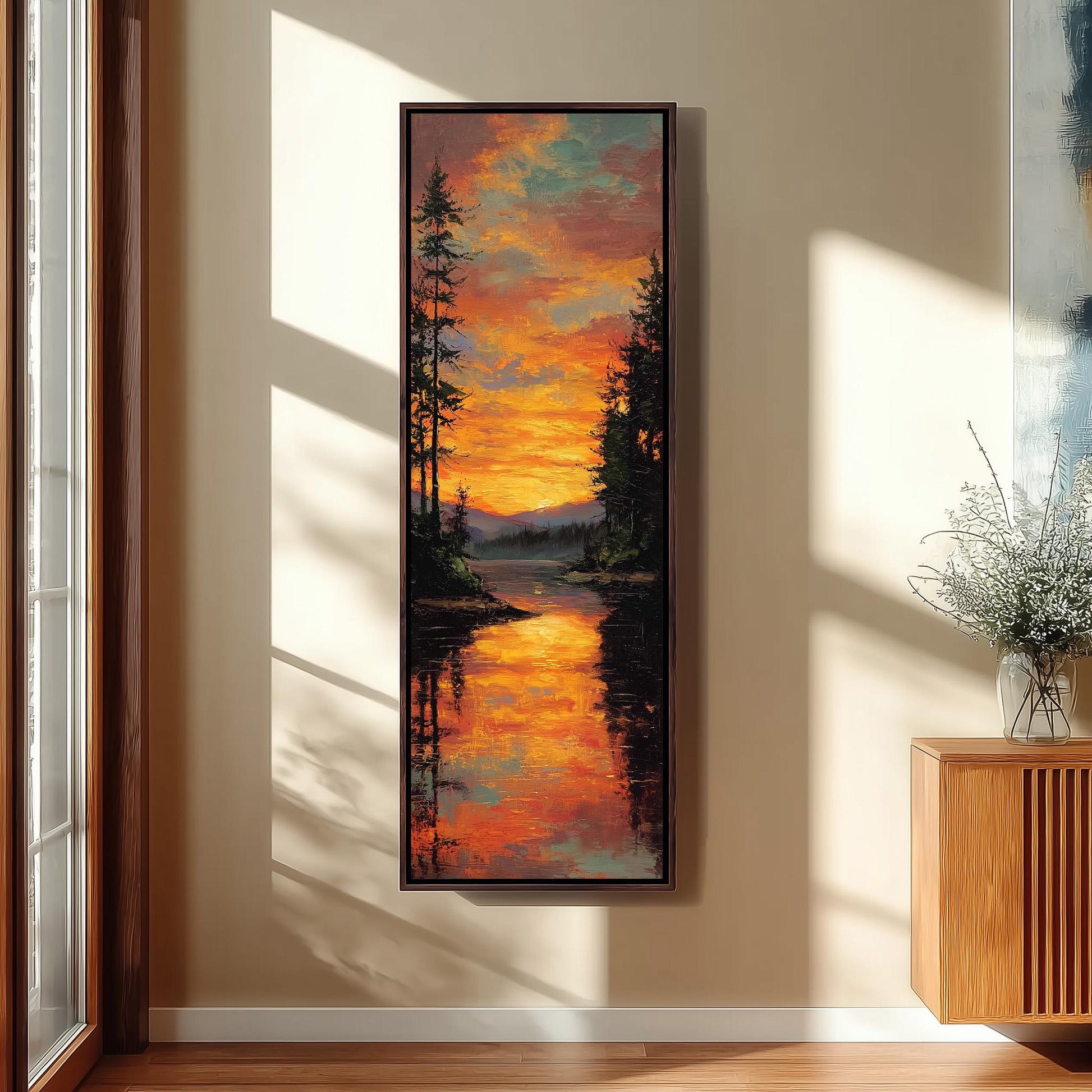 a large framed painting hanging on a wall, depicting a serene landscape with a lake reflecting the vibrant colors of the sunset.