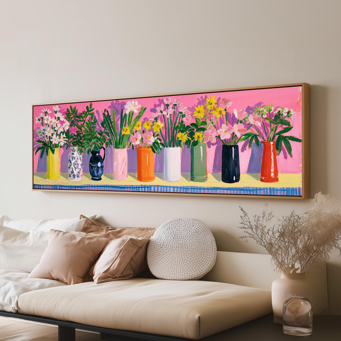 Folk art bouquets in colorful vases on pink long horizontal canvas print above a sofa in a living room