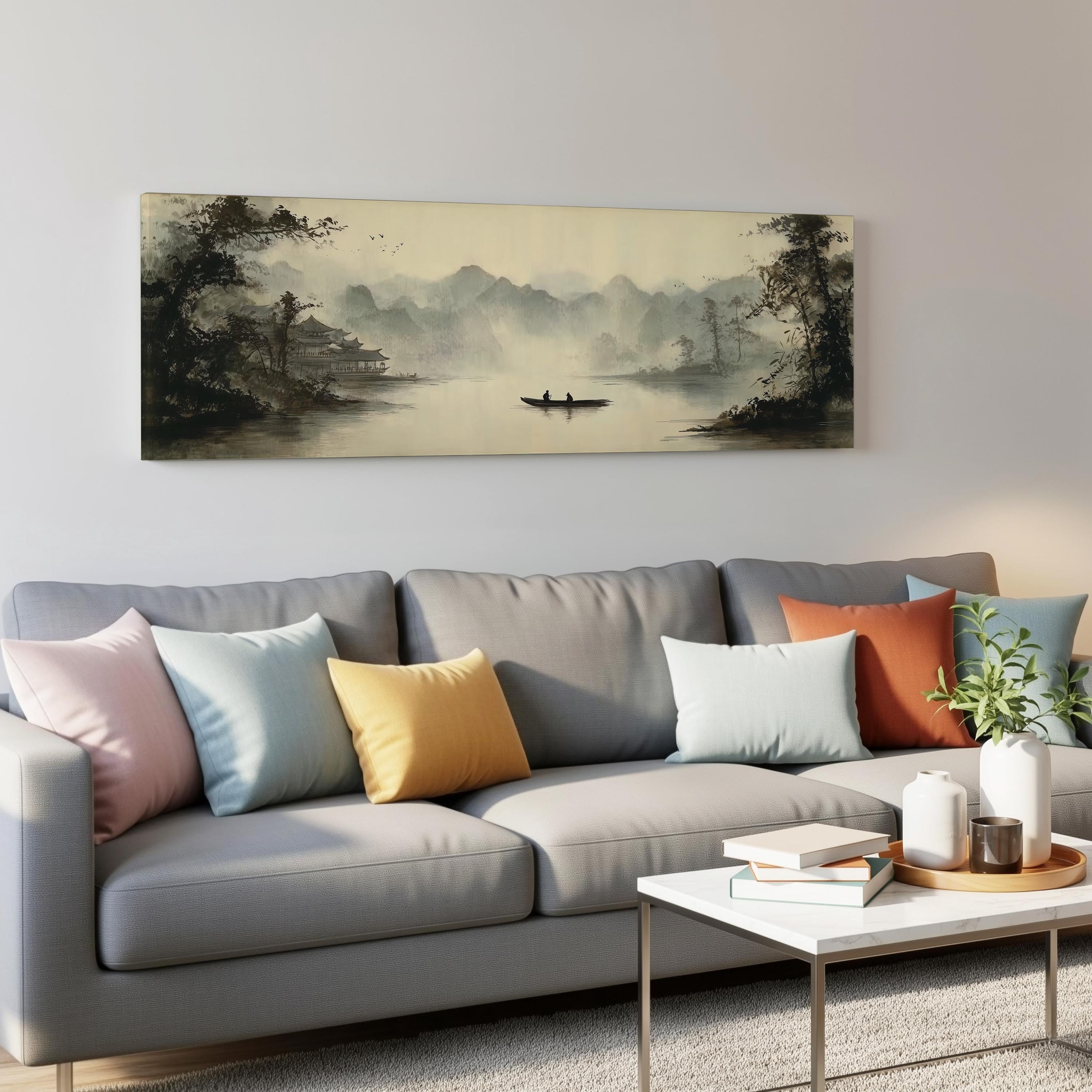 a gray couch with colorful throw pillows, a coffee table, and a painting of a boat on a lake hanging on the wall above it.