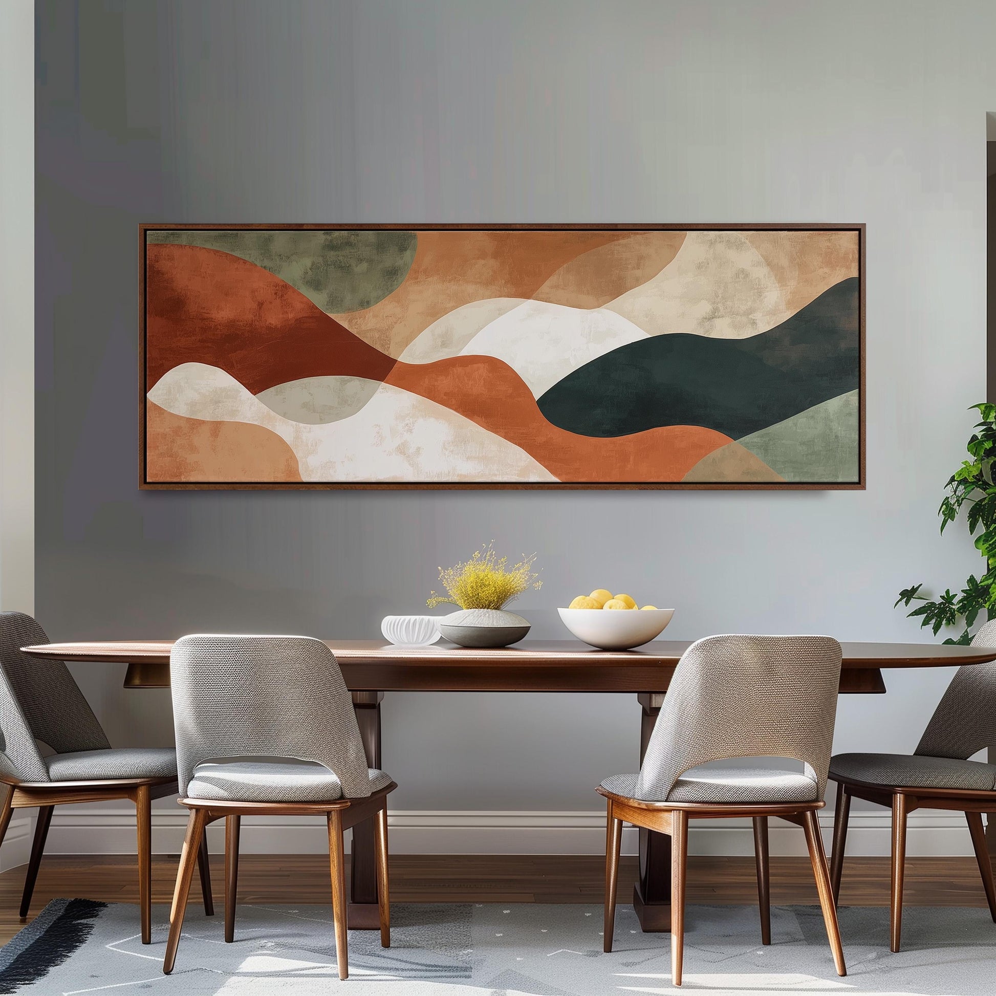 a modern dining room with a large abstract painting hanging on the wall above a wooden dining table with four chairs. The table is set with a bowl of fruit and a vase of flowers, creating a welcoming and stylish atmosphere.