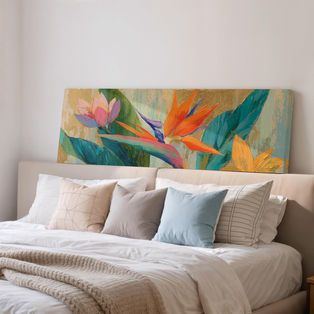 a large, colorful painting of tropical flowers hanging on a wall above a brown sofa.