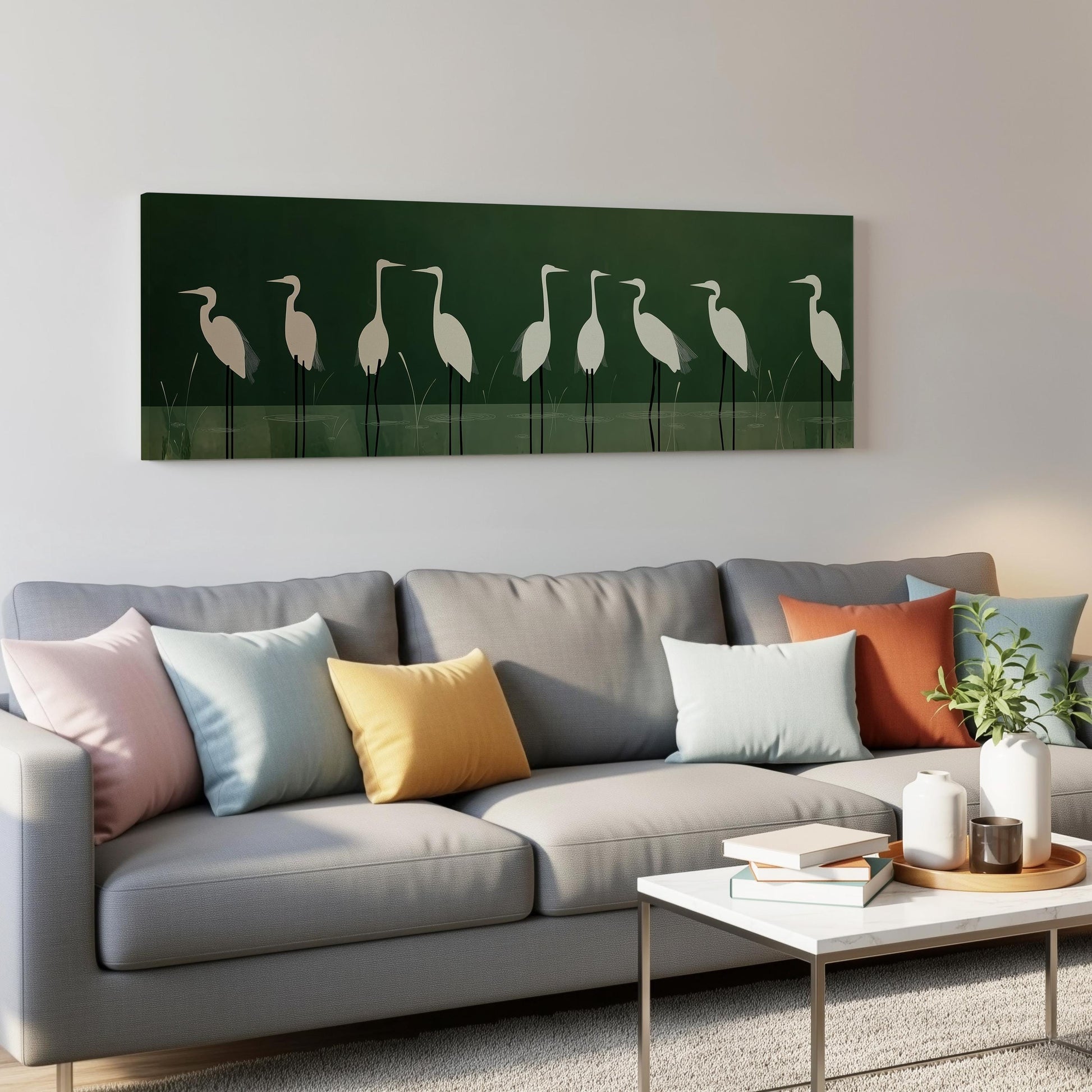 a gray couch with colorful throw pillows, a coffee table, and a framed artwork of white birds on a green background hanging on the wall above the couch.