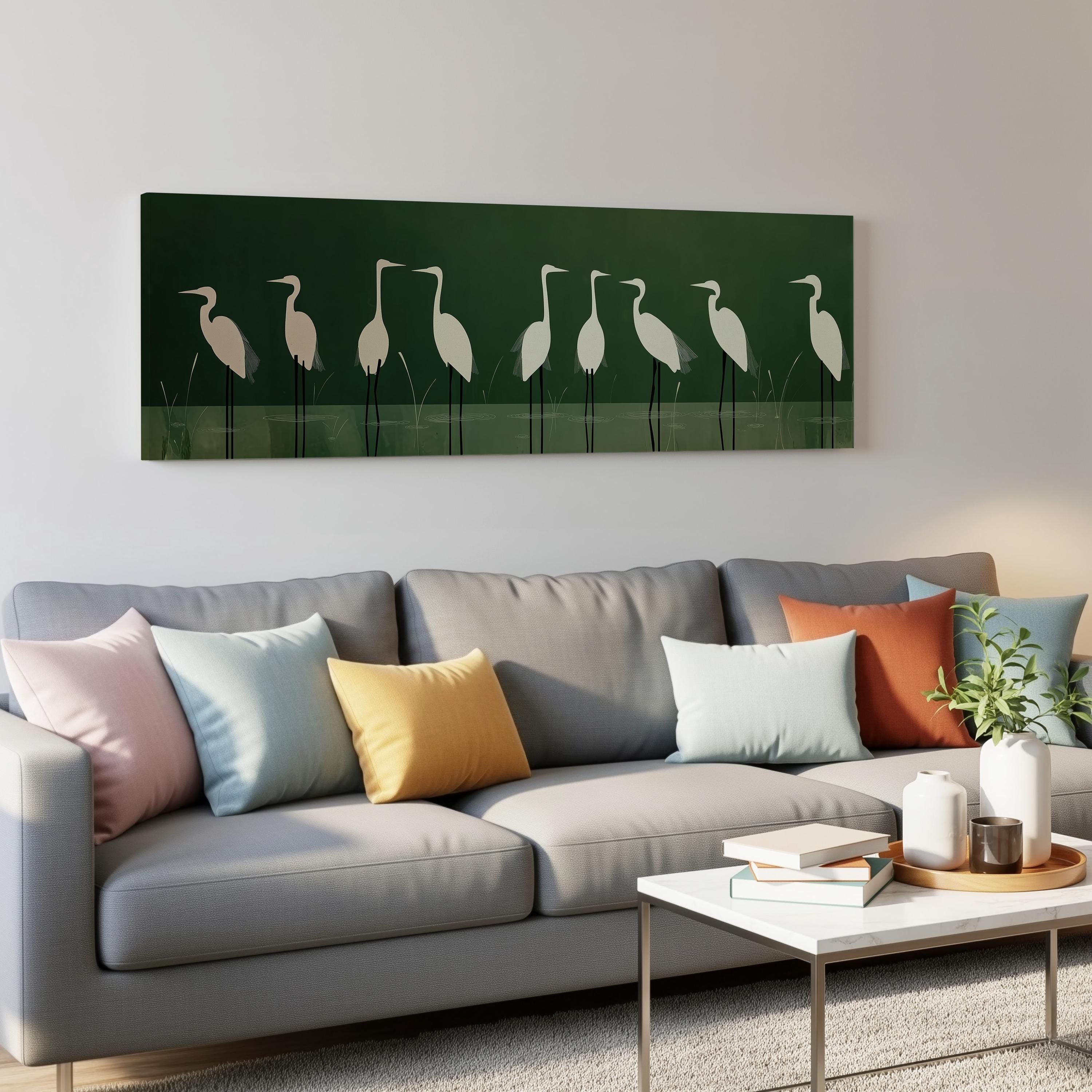 a gray couch with colorful throw pillows, a coffee table, and a framed artwork of white birds on a green background hanging on the wall above the couch.