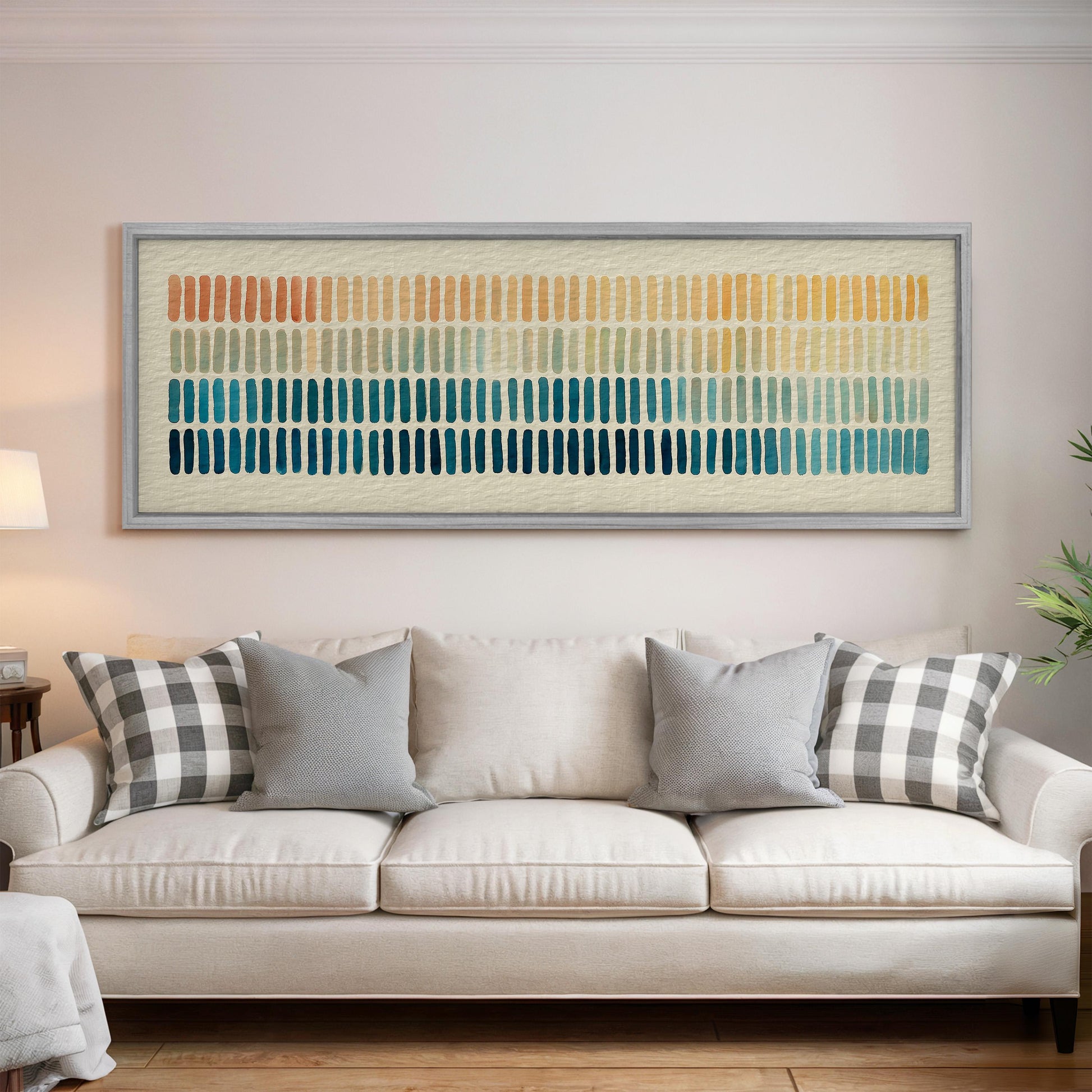 a large, colorful abstract painting hanging on a wall above a white couch with gray and black plaid throw pillows.