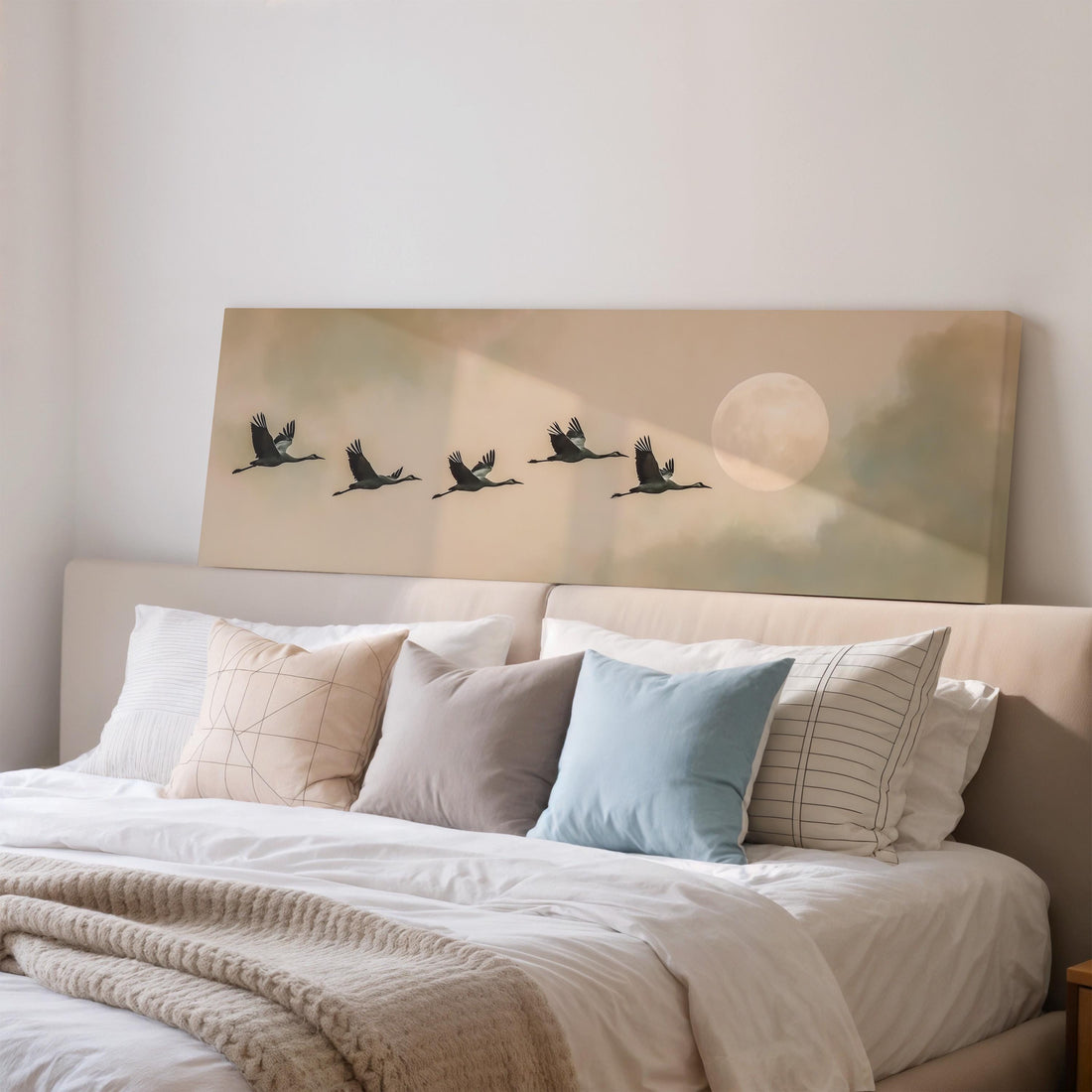 a large framed painting of a flock of birds flying in formation, with a full moon in the background.