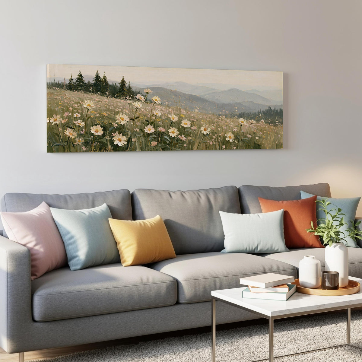 Daisy hillside below blue mountains panoramic canvas print above a grey sofa in a living room