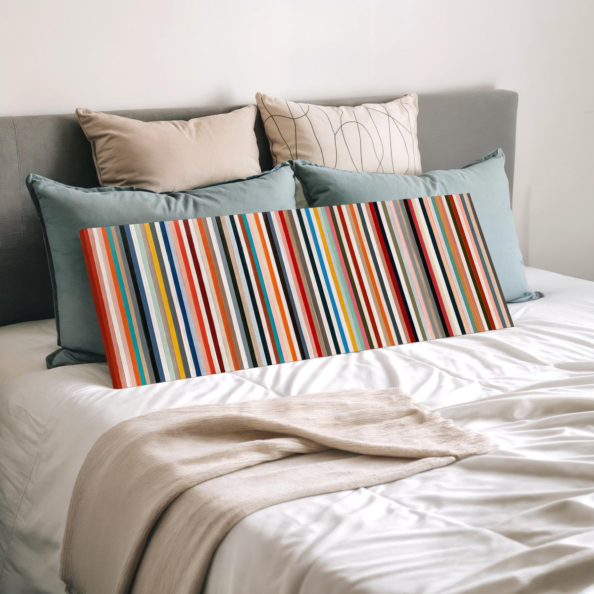 Rainbow pinstripes wide panoramic canvas print laid on a bed to show its size