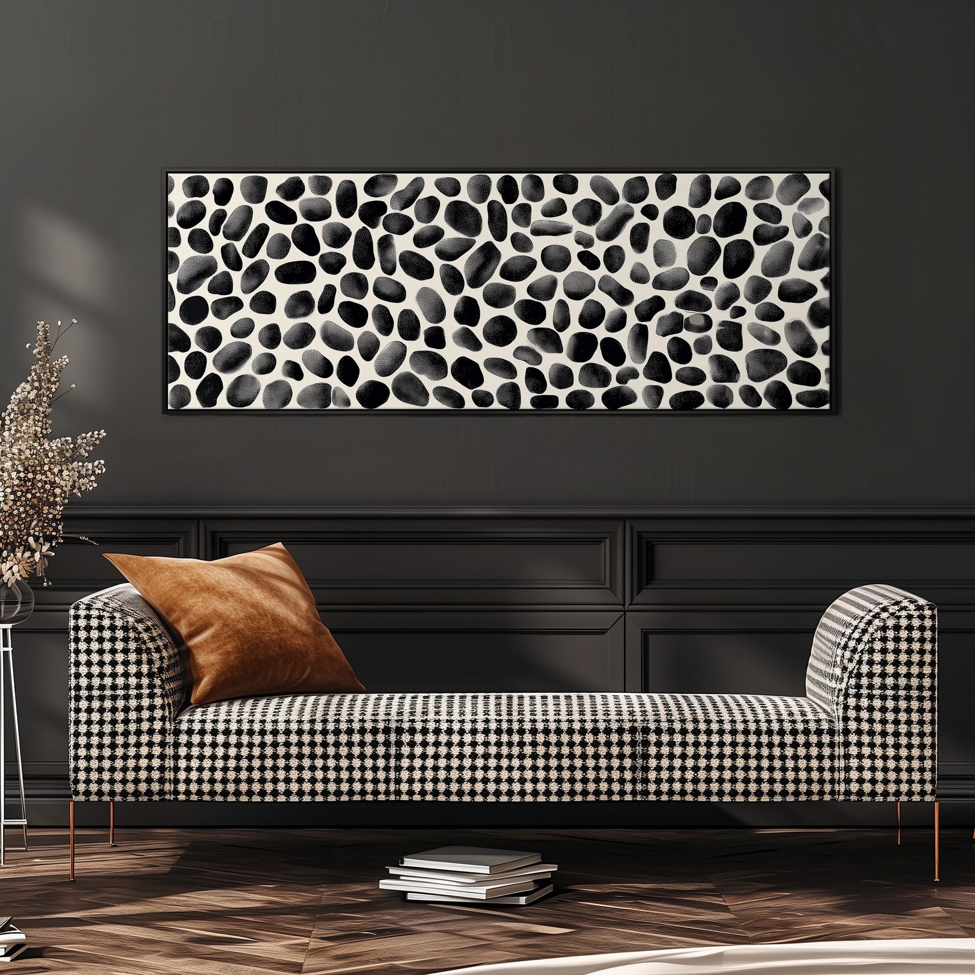 a modern living room with a black and white checkered sofa, a stack of books, and a large abstract painting on the wall.